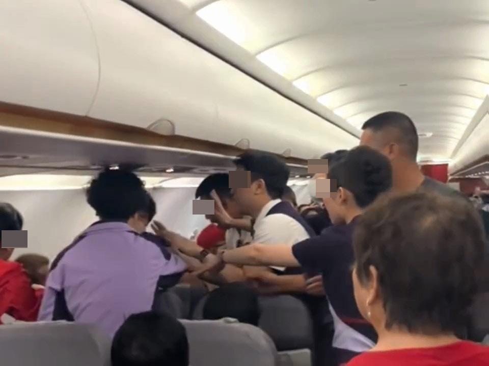 多名空姐、空少前來阻止,其中有空姐不斷以普通話高呼「坐下!不要動手!不要動手,給我坐下!全部人給我坐下!馬上坐下,不要再動手」。(影片截圖) 多名空姐、空少前來阻止,其中有空姐不斷以普通話高呼「坐下!不要動手!不要動手,給我坐下!全部人給我坐下!馬上坐下,不要再動手」。(影片截圖)