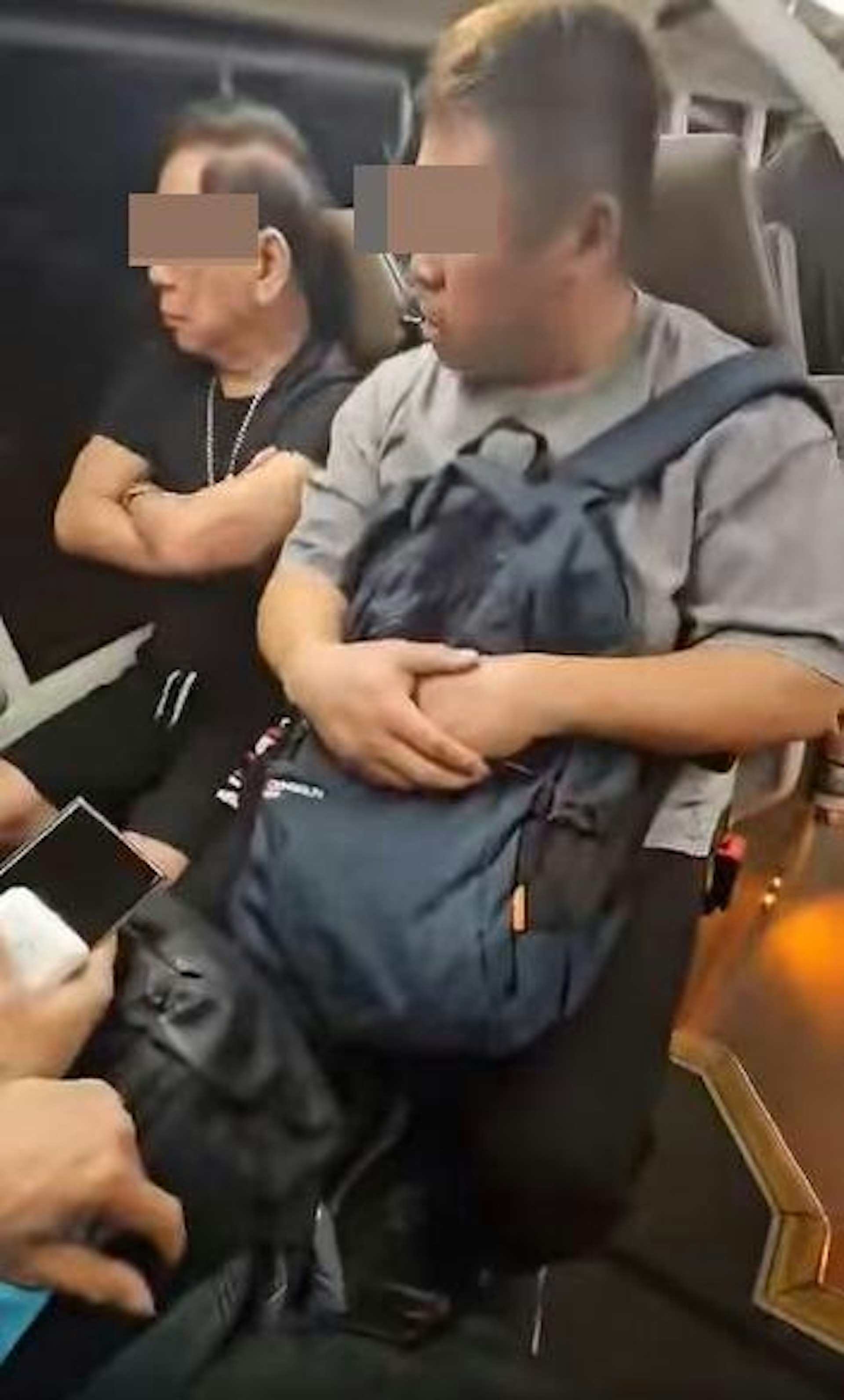 近玻璃窗的穿黑衣阿伯,正與旁邊的灰衣男乘客爭吵。(影片截圖) 近玻璃窗的穿黑衣阿伯,正與旁邊的灰衣男乘客爭吵。(影片截圖)