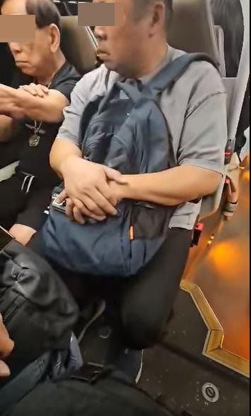 之後阿伯看到對座男乘客搖頭，轉而挑釁該男乘客「你做咩搖頭？」。（影片截圖）