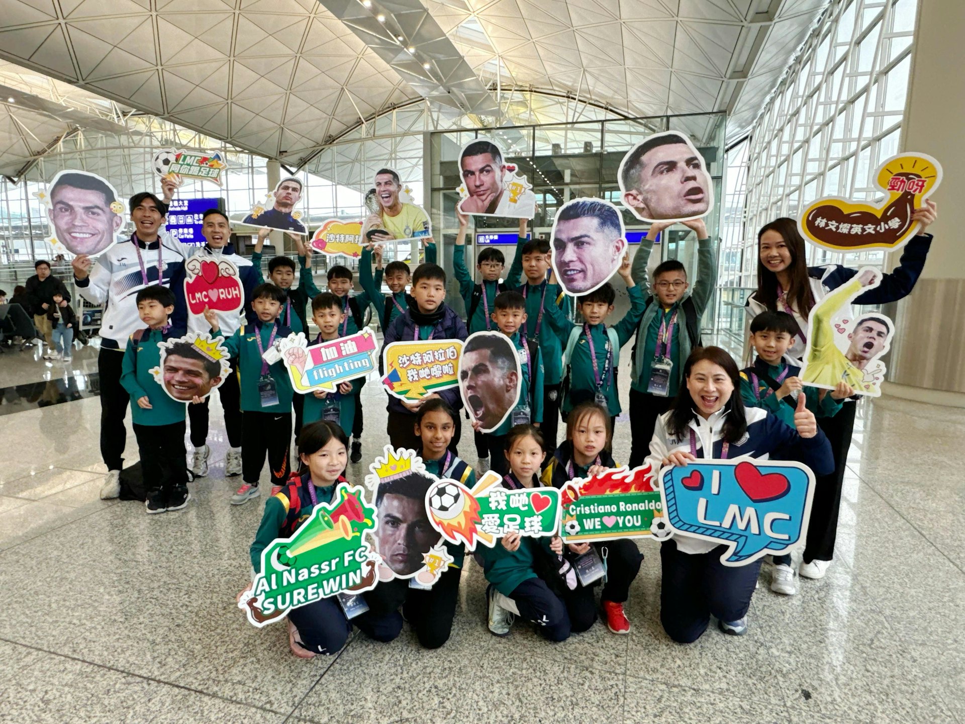 20多名師生在香港國際機場,準備踏上前往沙特阿拉伯的足球之旅,面帶興奮和期待的笑容。(保良局林文燦英文小學提供圖片) 20多名師生在香港國際機場,準備踏上前往沙特阿拉伯的足球之旅,面帶興奮和期待的笑容。(保良局林文燦英文小學提供圖片)