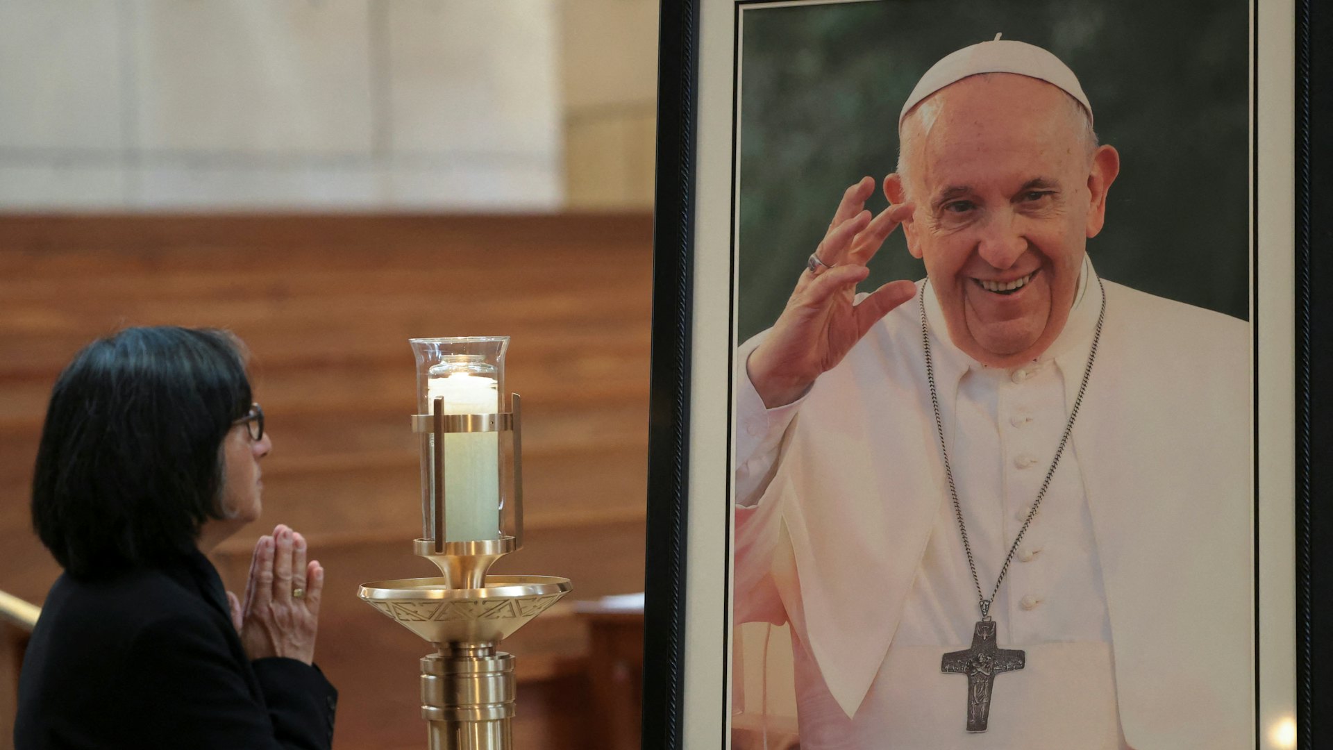 2025年4月21日,美國加州洛杉磯,教宗方濟各去世後,一名信眾站在天使之后主教座堂(Cathedral of Our Lady of the Angels)展示的教宗方濟各(Pope Francis)肖像前祈禱。(Reuters)