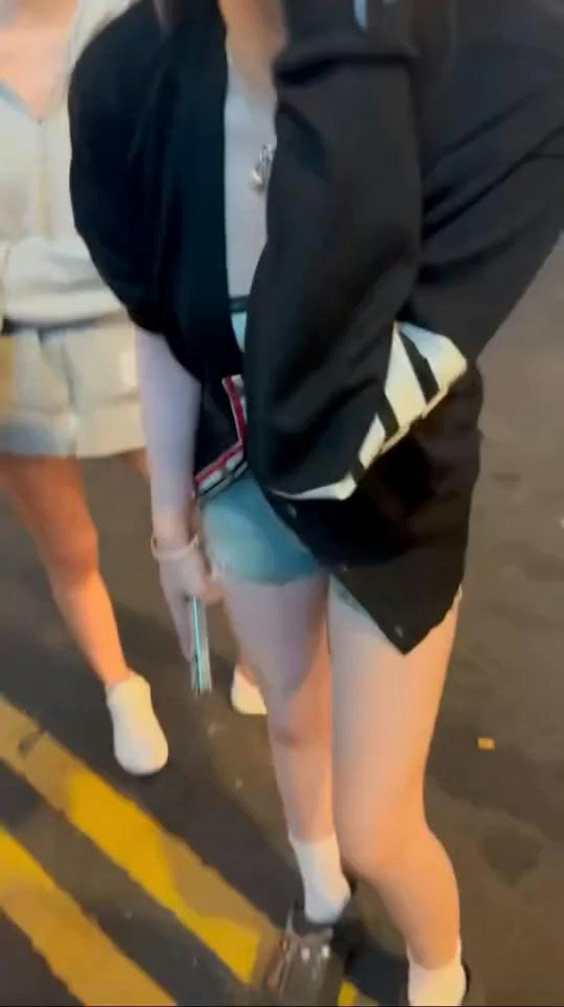 鏡頭右方、穿黑色外套藍色熱褲「MK妹」拍打自己左臉,揚言「打我啦!打我啦好無啊?求下妳打我啦!」。(hey_iam_vivi/threads影片截圖)