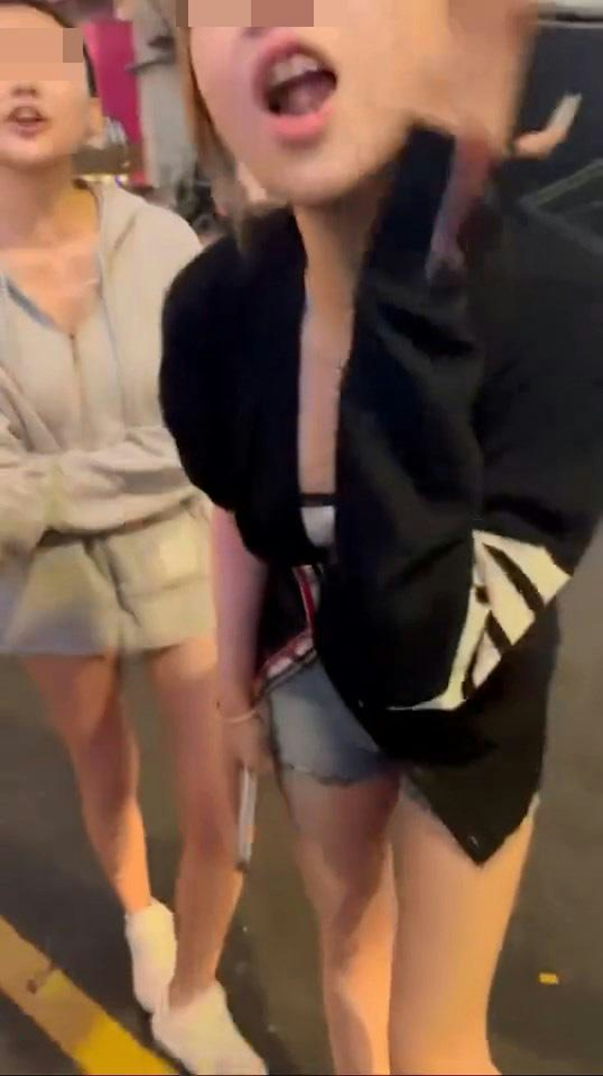 鏡頭右方、穿黑色外套藍色熱褲「MK妹」拍打自己左臉,揚言「打我啦!打我啦好無啊?求下妳打我啦!」。(hey_iam_vivi/threads影片截圖)