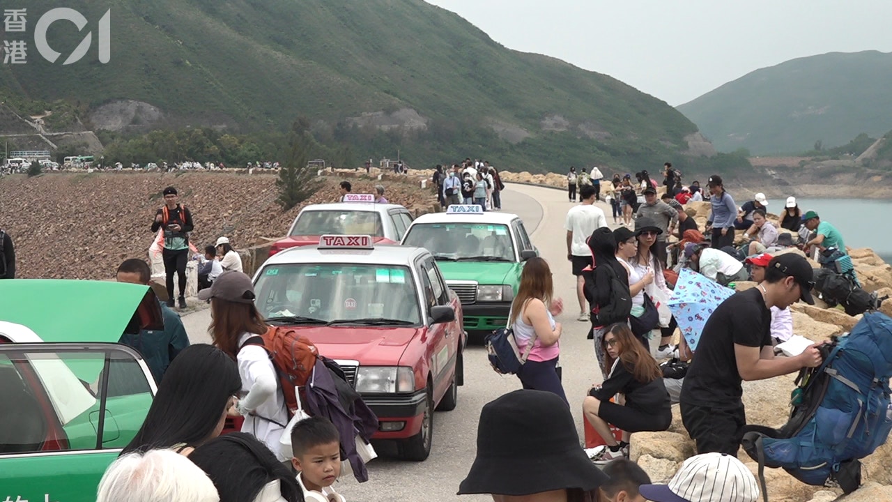 圖為2025年5月1日，大批旅客在東壩坐在兩旁路邊。(何頴賢攝)