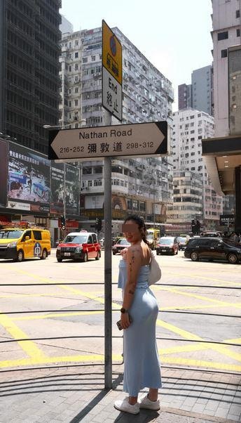 樓主站在彌敦道路牌下方，擺出不同姿勢「打卡」，露出開心笑容。（threads圖片）