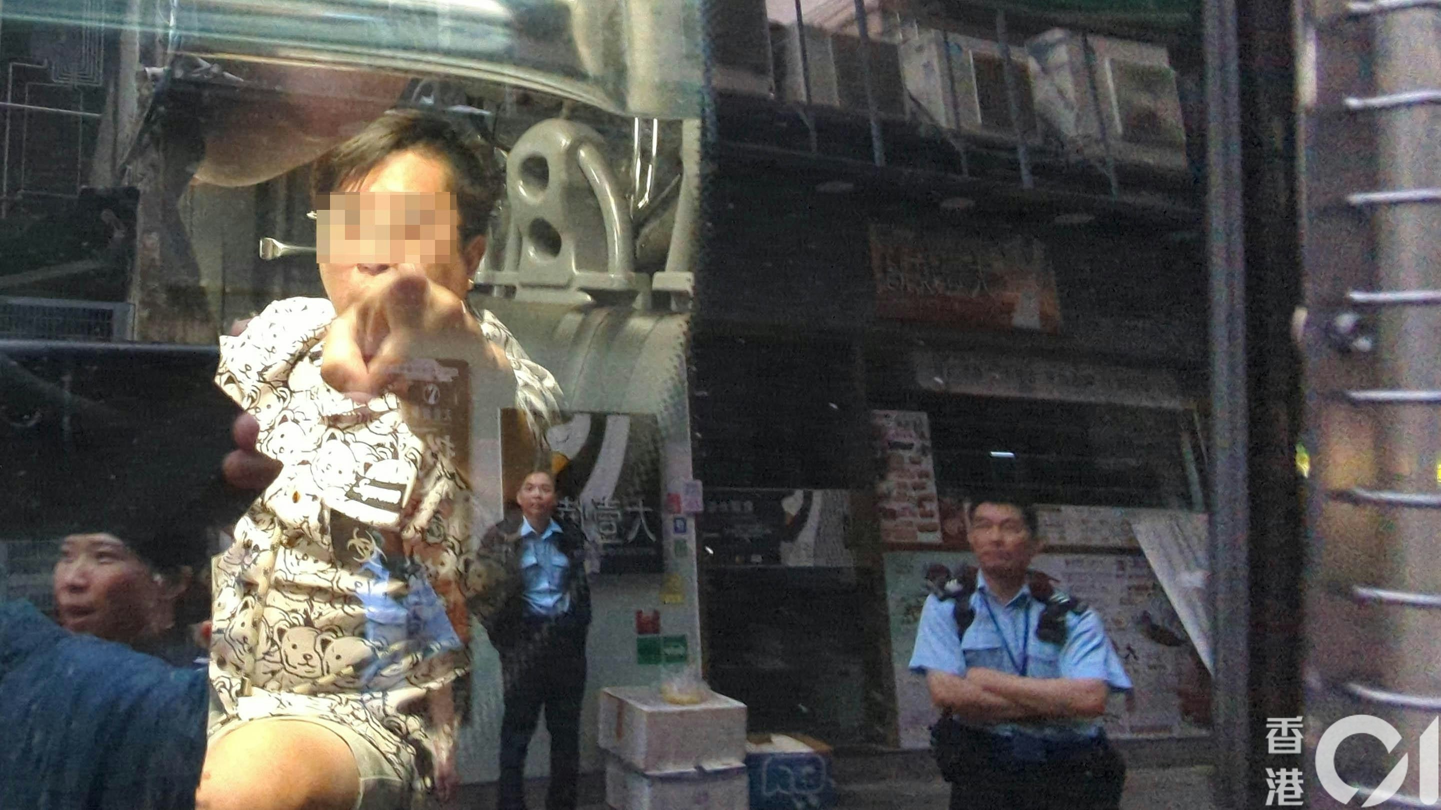 被捕男子被帶上警車，見到記者拍攝時破口大罵。（黃偉民攝）