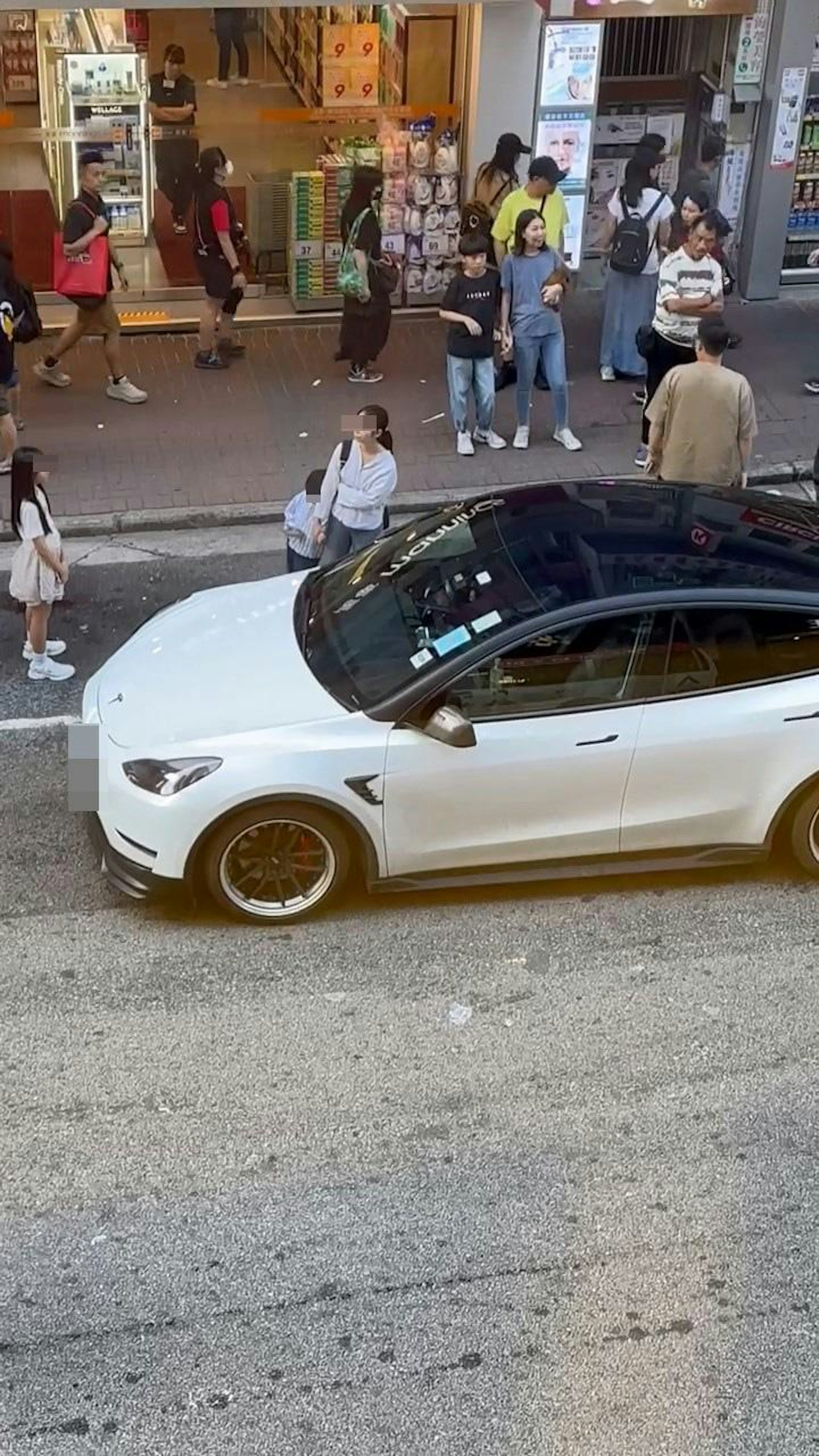 旺角弼街萬寧對出有1名女子帶着1名男童及1名女童站在停車格上,阻礙其他車輛駛入使用。(Facebook群組「馬路的事討論區」)