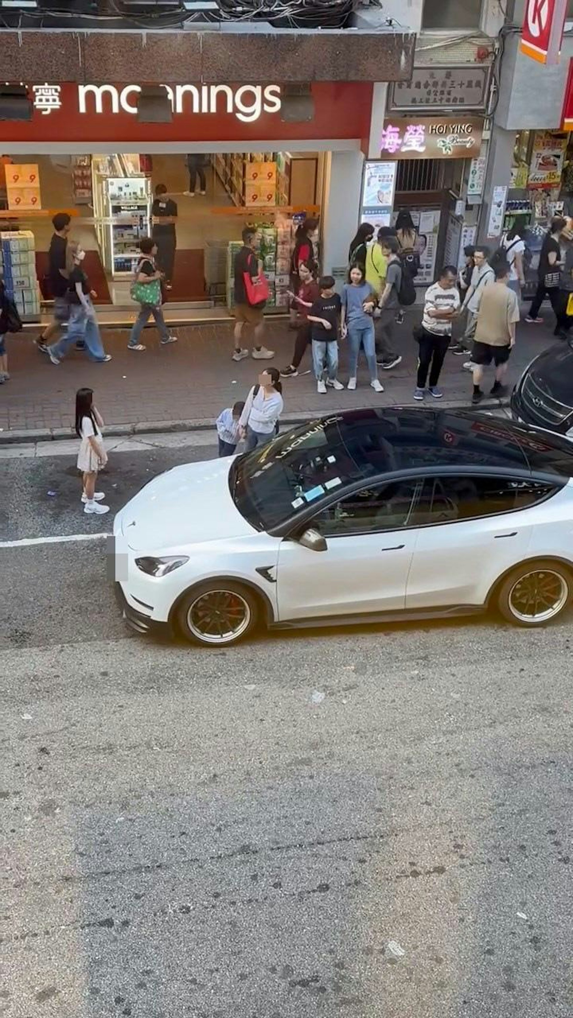 旺角弼街萬寧對出有1名女子帶着1名男童及1名女童站在停車格上,阻礙其他車輛駛入使用。(Facebook群組「馬路的事討論區」)