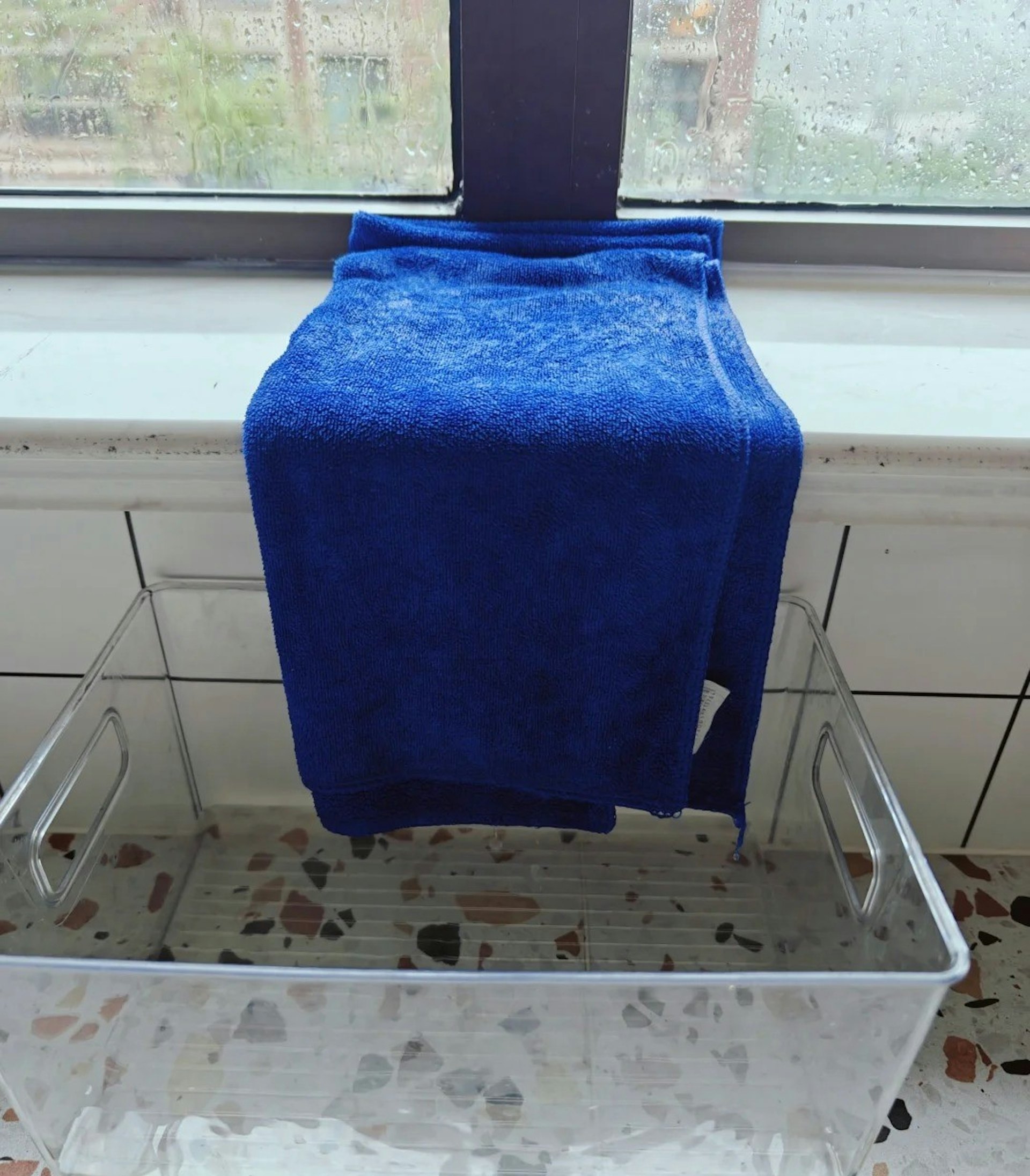 把毛巾塞在窗邊,然後將毛巾的一邊懸在窗台,下面放一個水桶,毛巾吸滿水後便會滴進水桶內。(小紅書@琴姐呀)