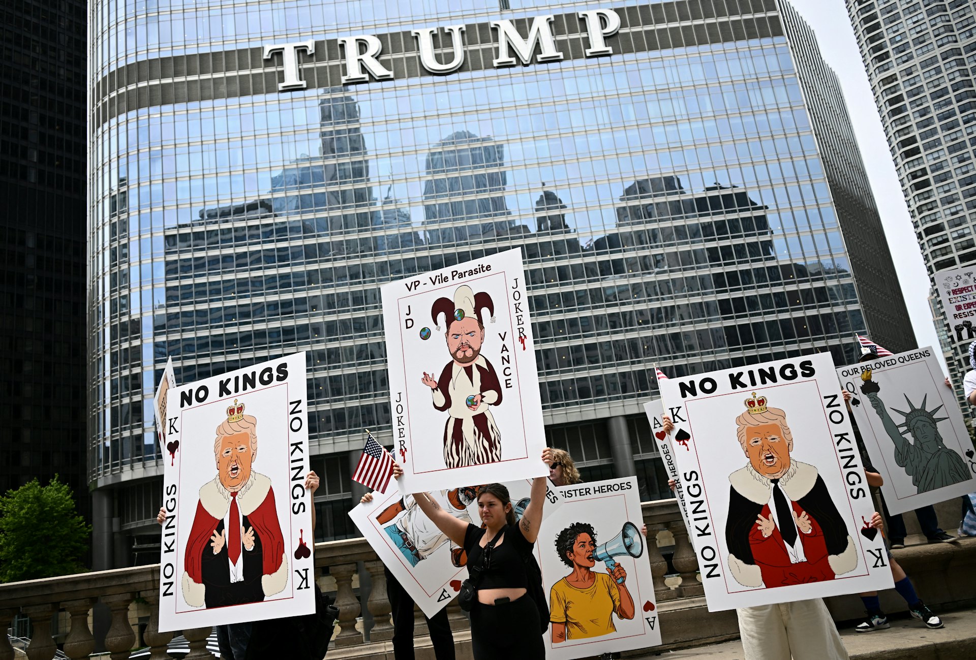 2025年6月15日在美國芝加哥,示威者舉起畫有「特朗普國王」、「萬斯小丑」卡牌圖像的標語,高呼「不要國王」(Reuters)