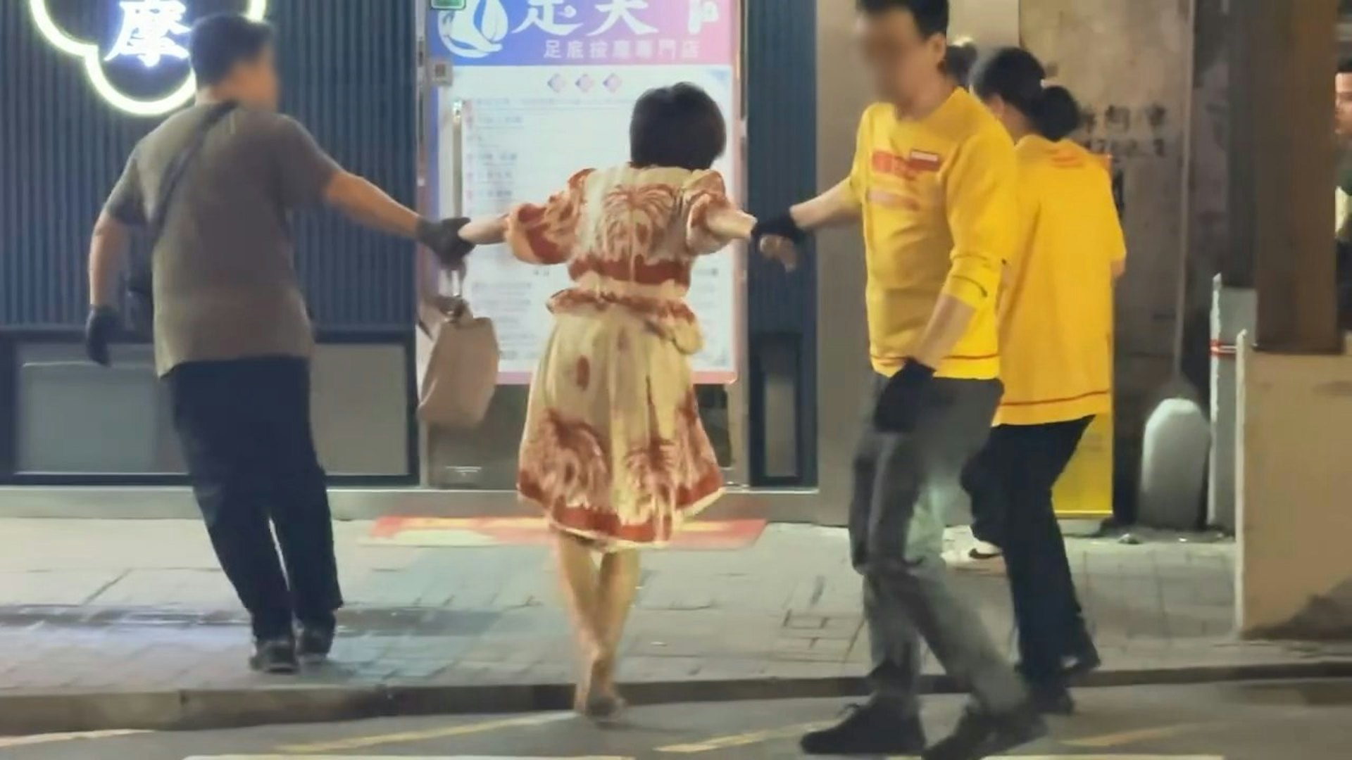 職員與身穿連身裙的赤腳女疑犯,在店舖對面上海街路邊拉扯。(Gordon Chan / 香港突發事故報料區 影片截圖)