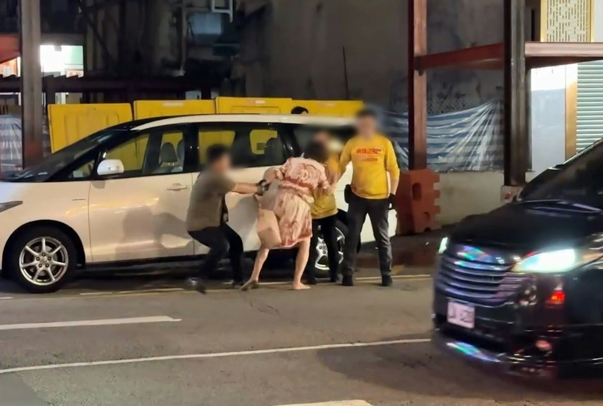 其中一片段見到,職員與身穿連身裙的赤腳女疑犯,在店舖對面上海街馬路邊拉扯。(Gordon Chan / 香港突發事故報料區 影片截圖)