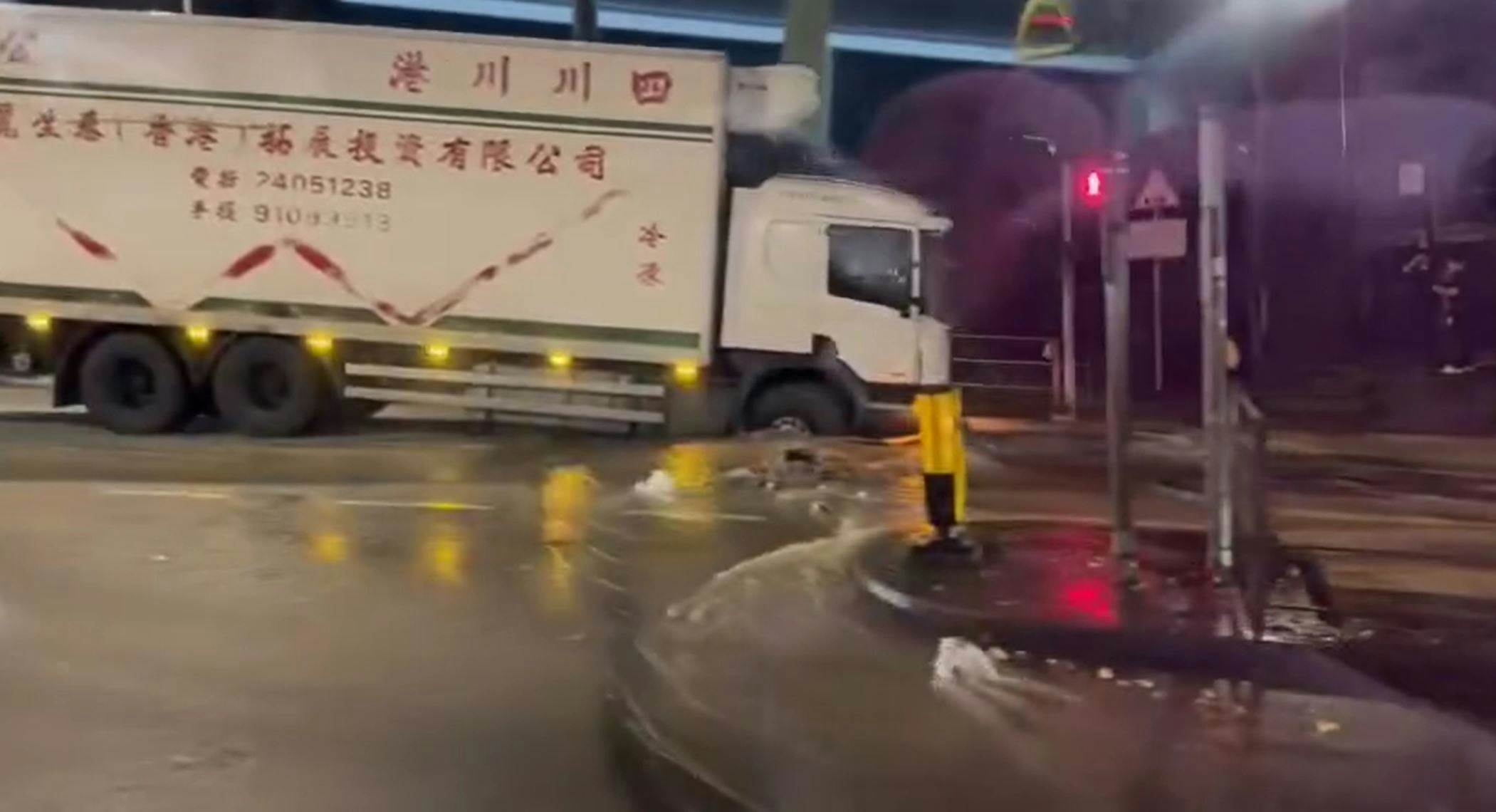 貨車前輪卡在路坑，整輛車向前傾斜，並有水從坑內湧出。（fb我們都是石籬邨長大的/林紹輝）