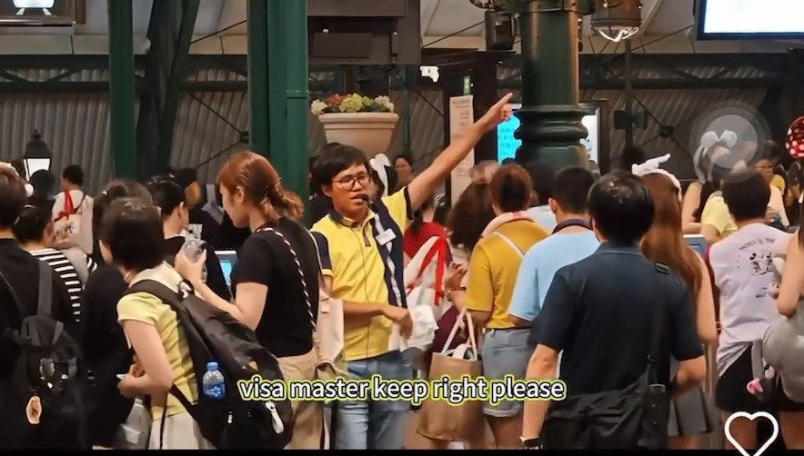 該男職員站在入口附近，以普通話、粵語及英語「Rap」出分流指示。（Threads影片截圖）