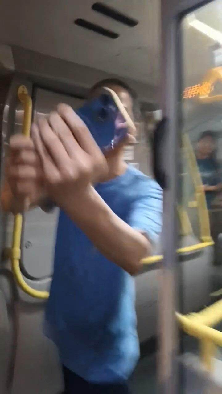 穿藍色上衣大叔站在車頭位置，與拍片者舉機互拍。（影片截圖）