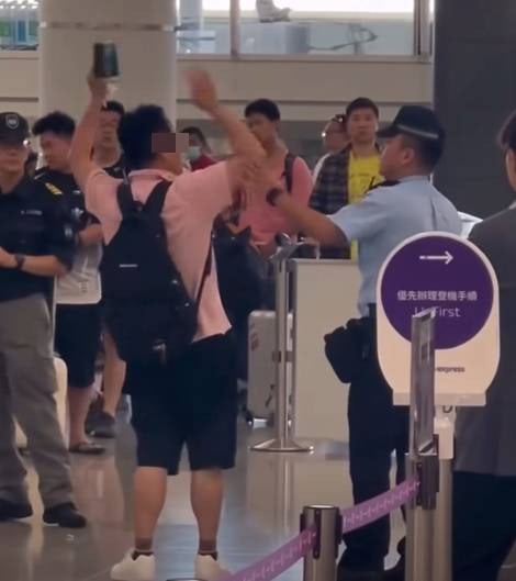 涉事男子舉起雙手在香港快運櫃位大吵大鬧，警員接報到場安撫其情緒。（facebook／車cam L（香港群組）至尊寶）