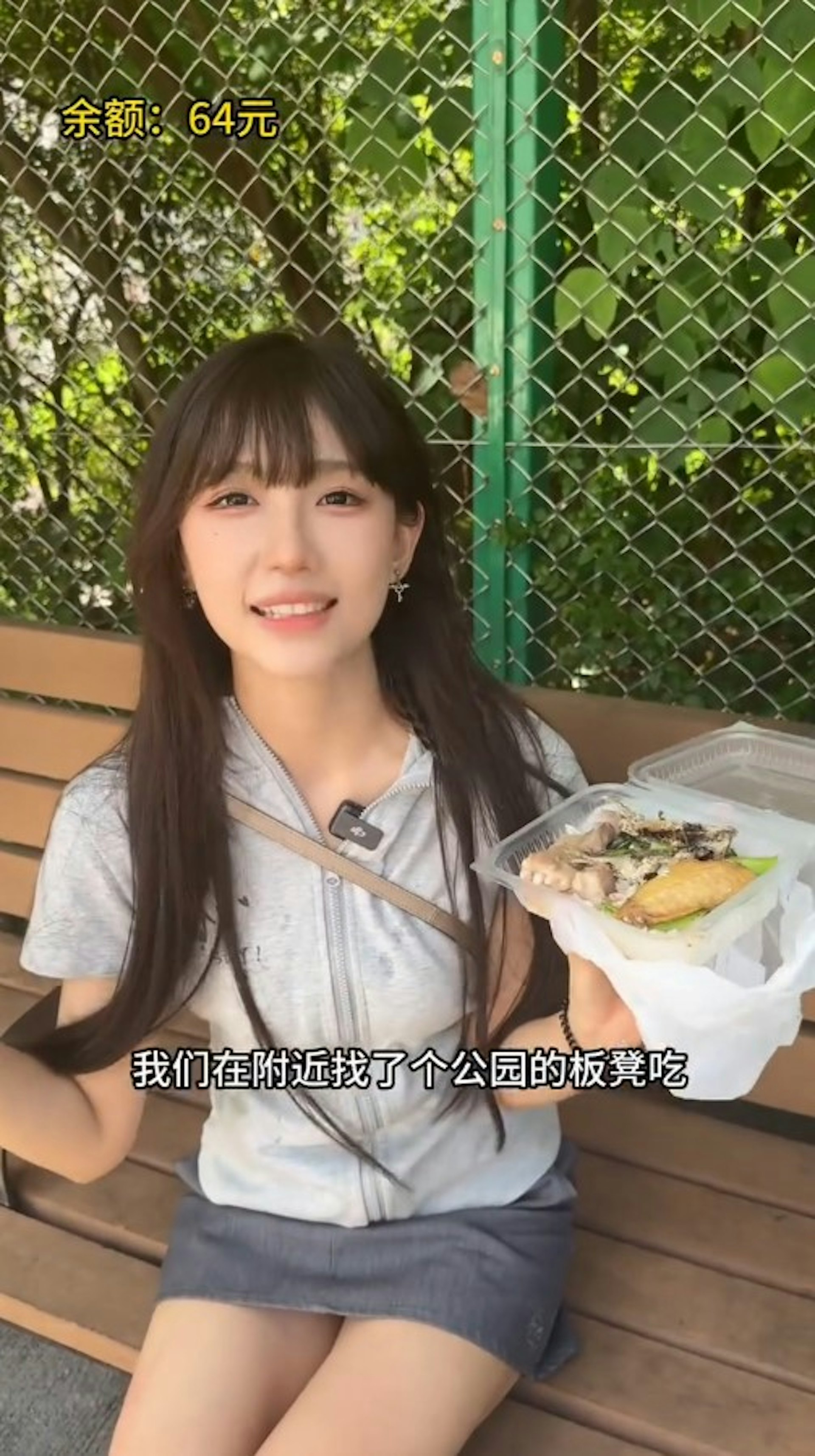 鍾婷在附近公園找到一張長凳坐下吃飯,可見到飯盒中有炸魚、排骨和雞翼三餸。(抖音影片截圖)