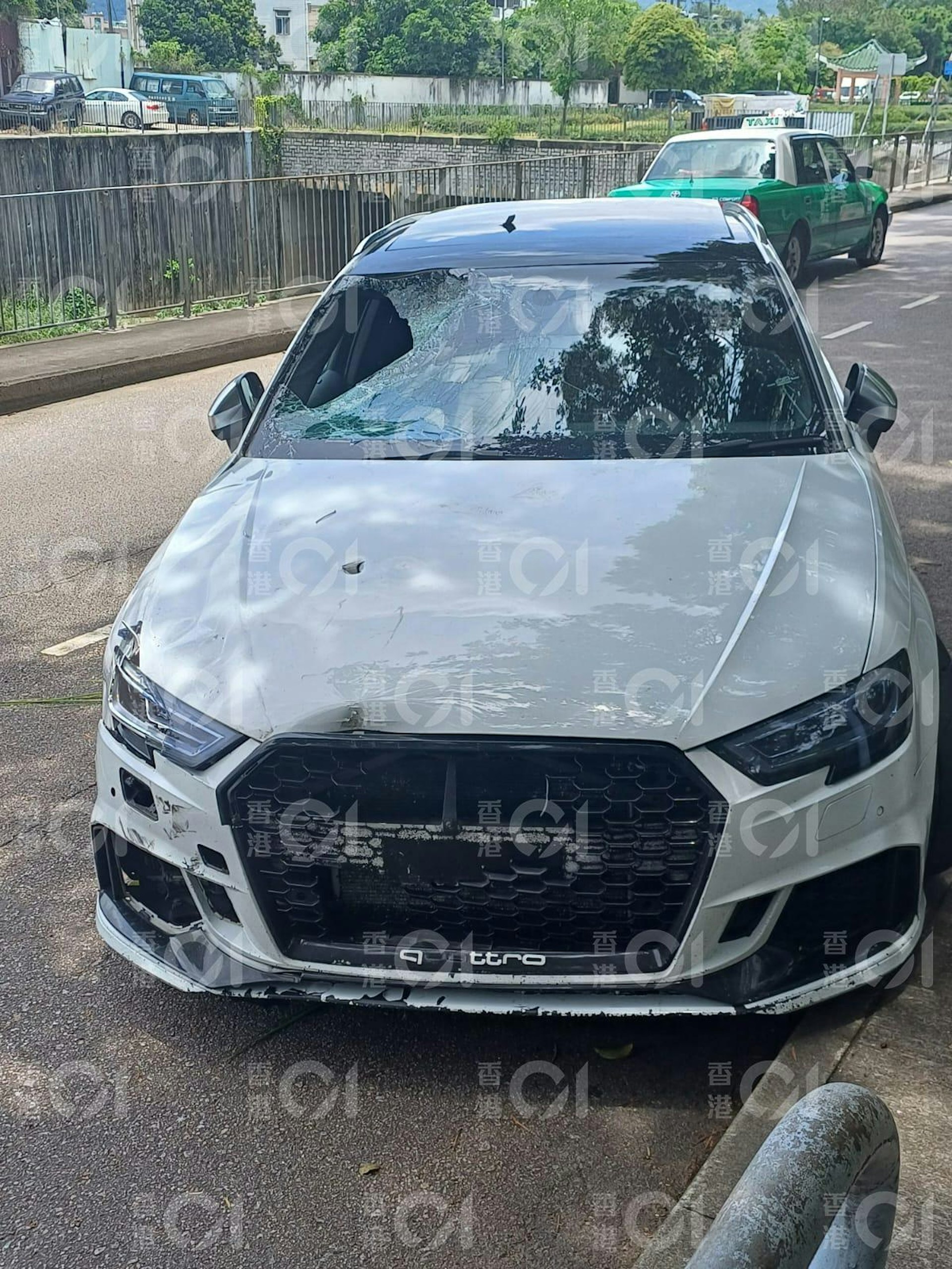 涉案白色奧迪(Audi),事後傾斜停泊於元朗朗河路近港頭村對開馬路邊;前、後車牌均不知所終。(讀者提供) 涉案白色奧迪(Audi),事後傾斜停泊於元朗朗河路近港頭村對開馬路邊;前、後車牌均不知所終。(讀者提供)
