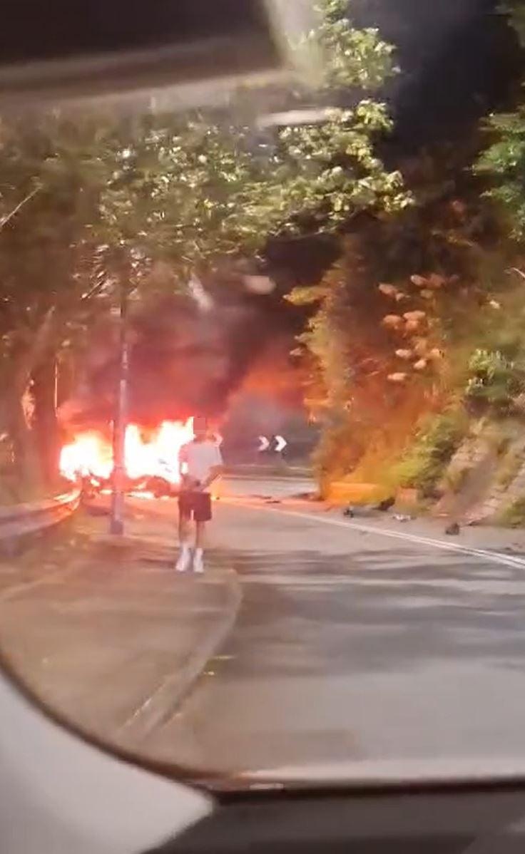 私家車陷入火海，一名女子驚呼「X！What the fxxk！成架車燒咗 」，一名外籍男子站在行人路。（facebook專頁「香港公共交通智庫」影片截圖）