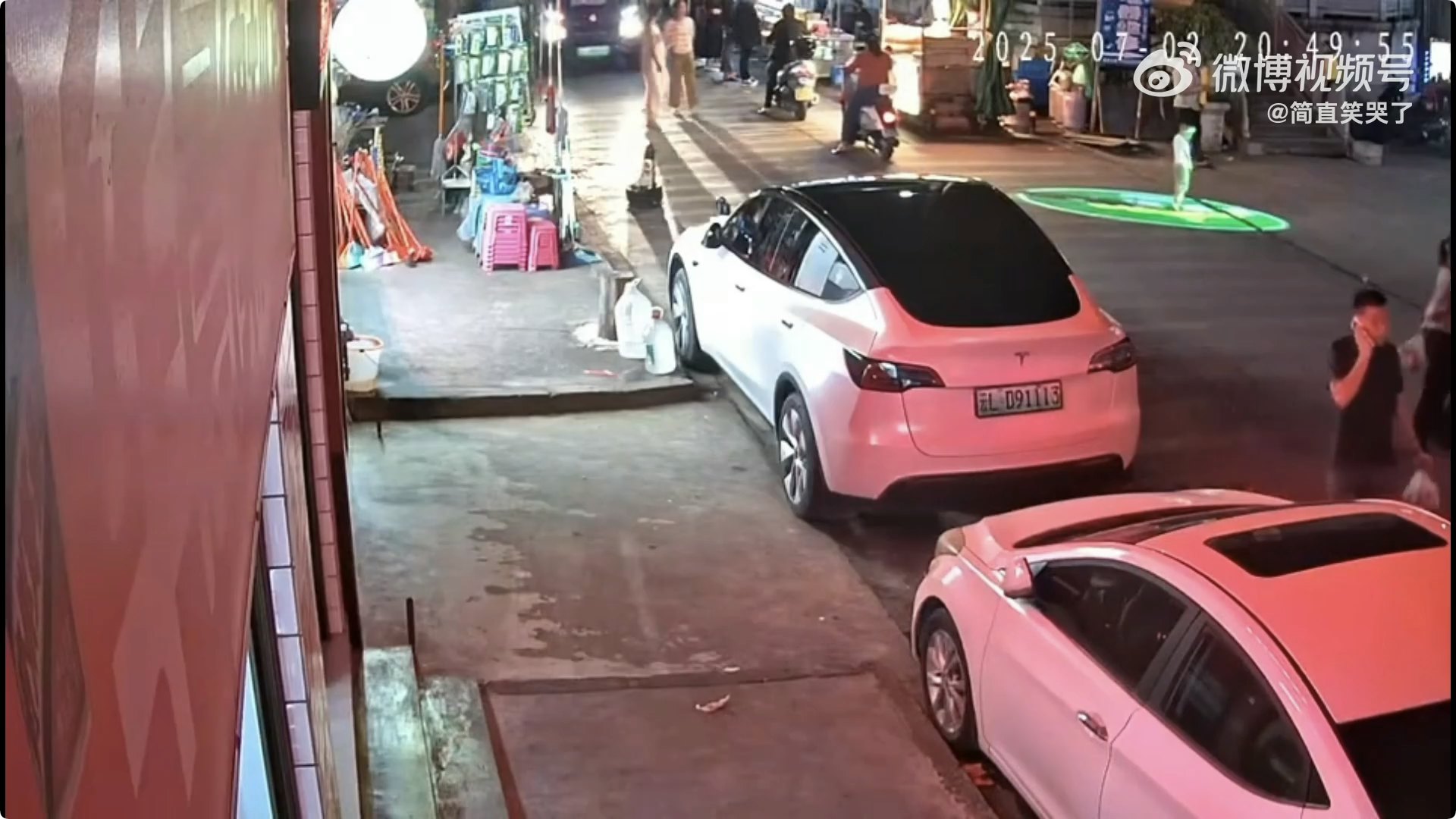 男童站在路口門頭廣告投影燈產生的光影下玩耍。(影片截圖)