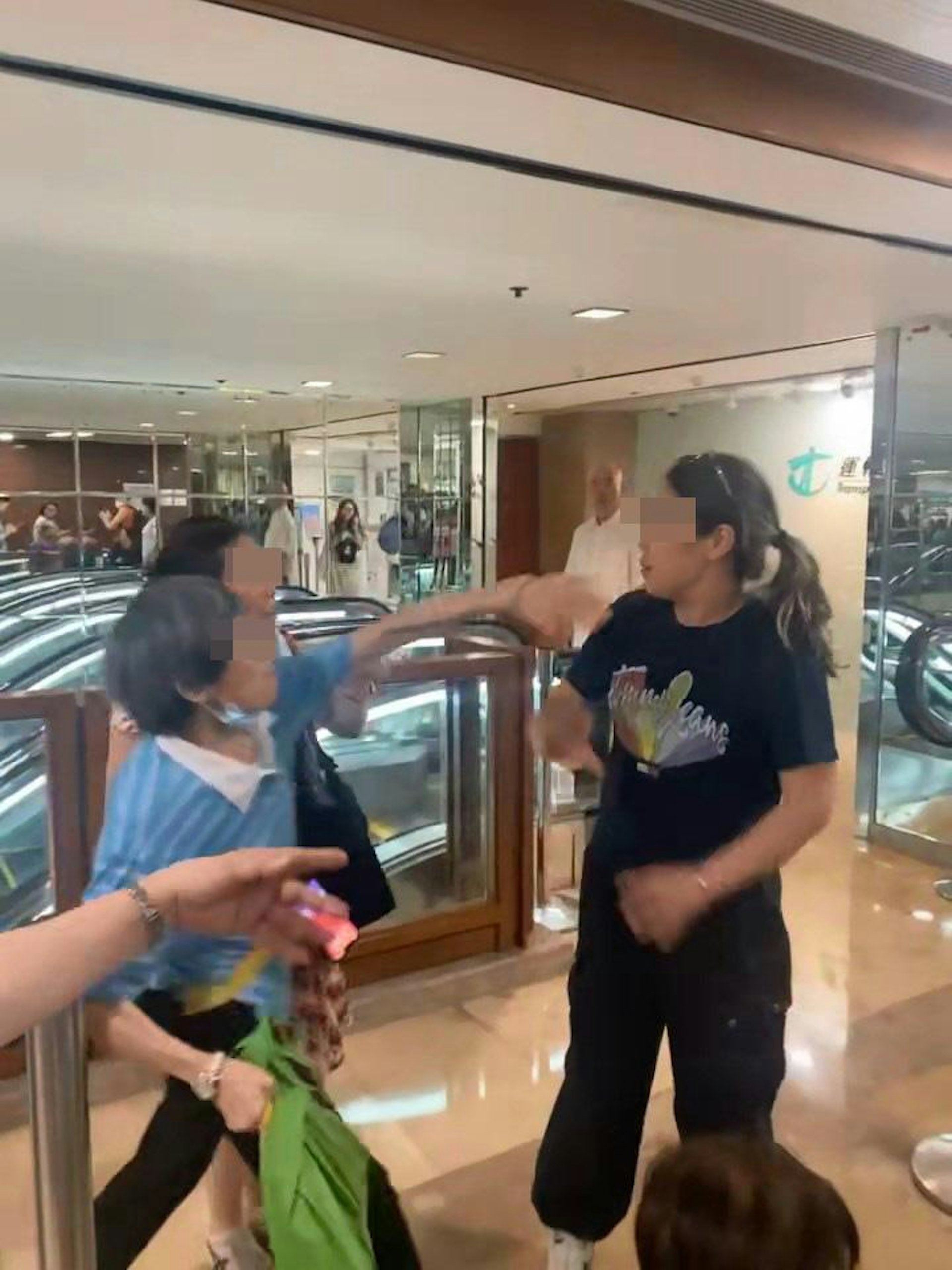 阿婆激動大力伸出左手攻擊黑衣女頭部。(adonis_the_explorer/Threads影片截圖)