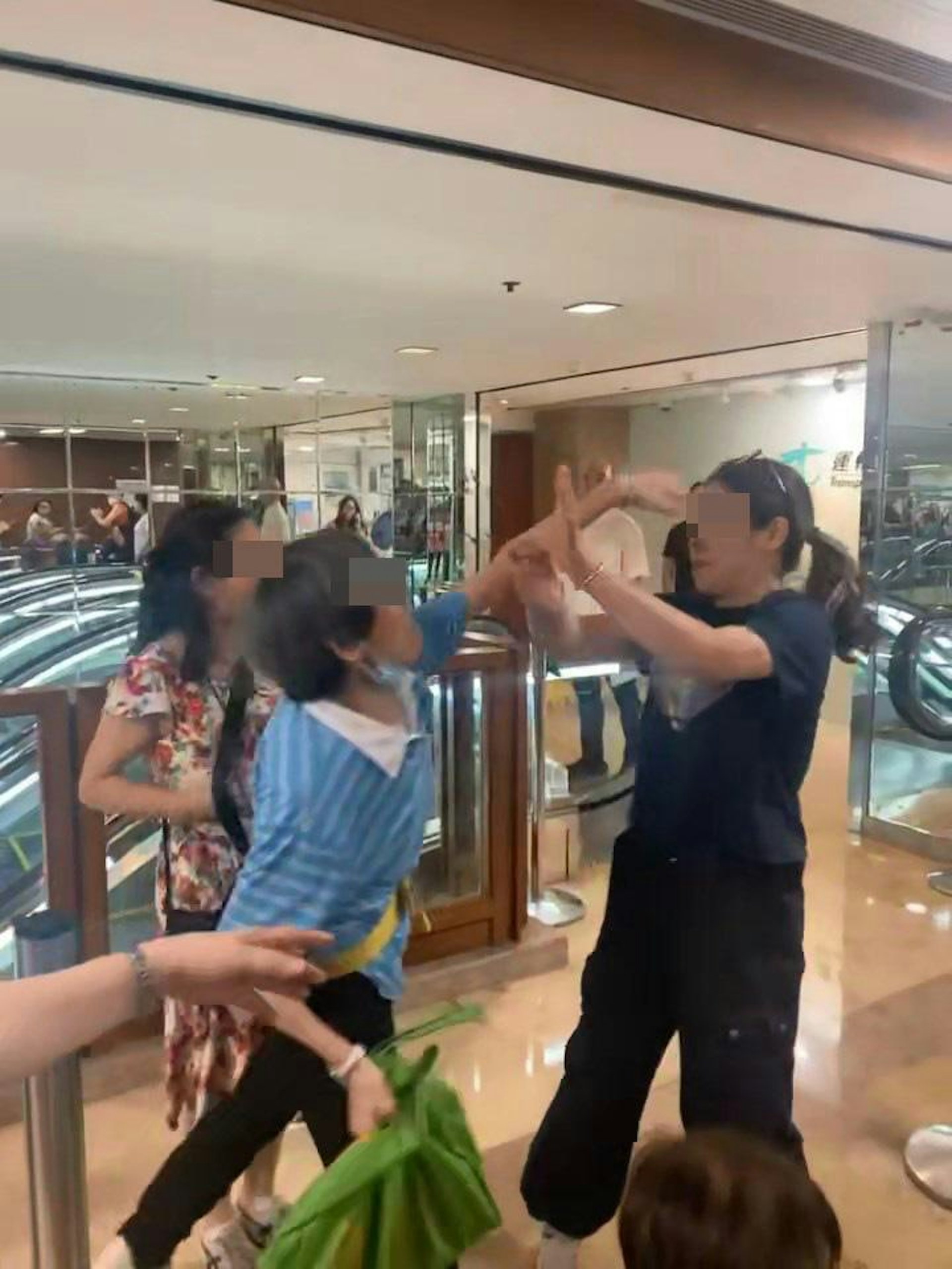 阿婆激動大力伸出左手攻擊黑衣女頭部。(adonis_the_explorer/Threads影片截圖)