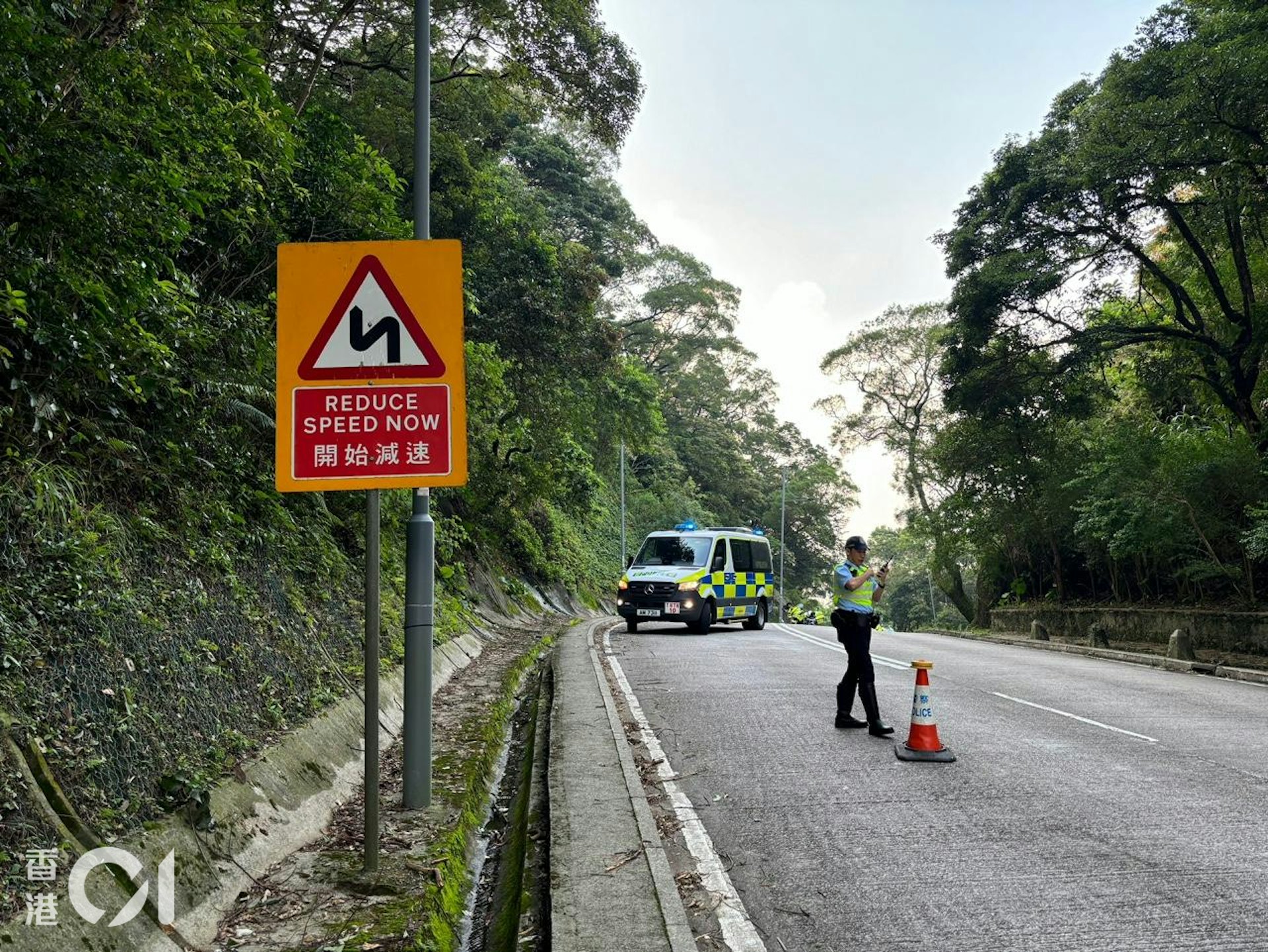 荃錦公路有電單車失事,鐵騎士不治;現場前方不遠處設有一個提示車輛開始減速及前方有連續彎路的交通標誌,警方在現場調查。(王譯揚攝)