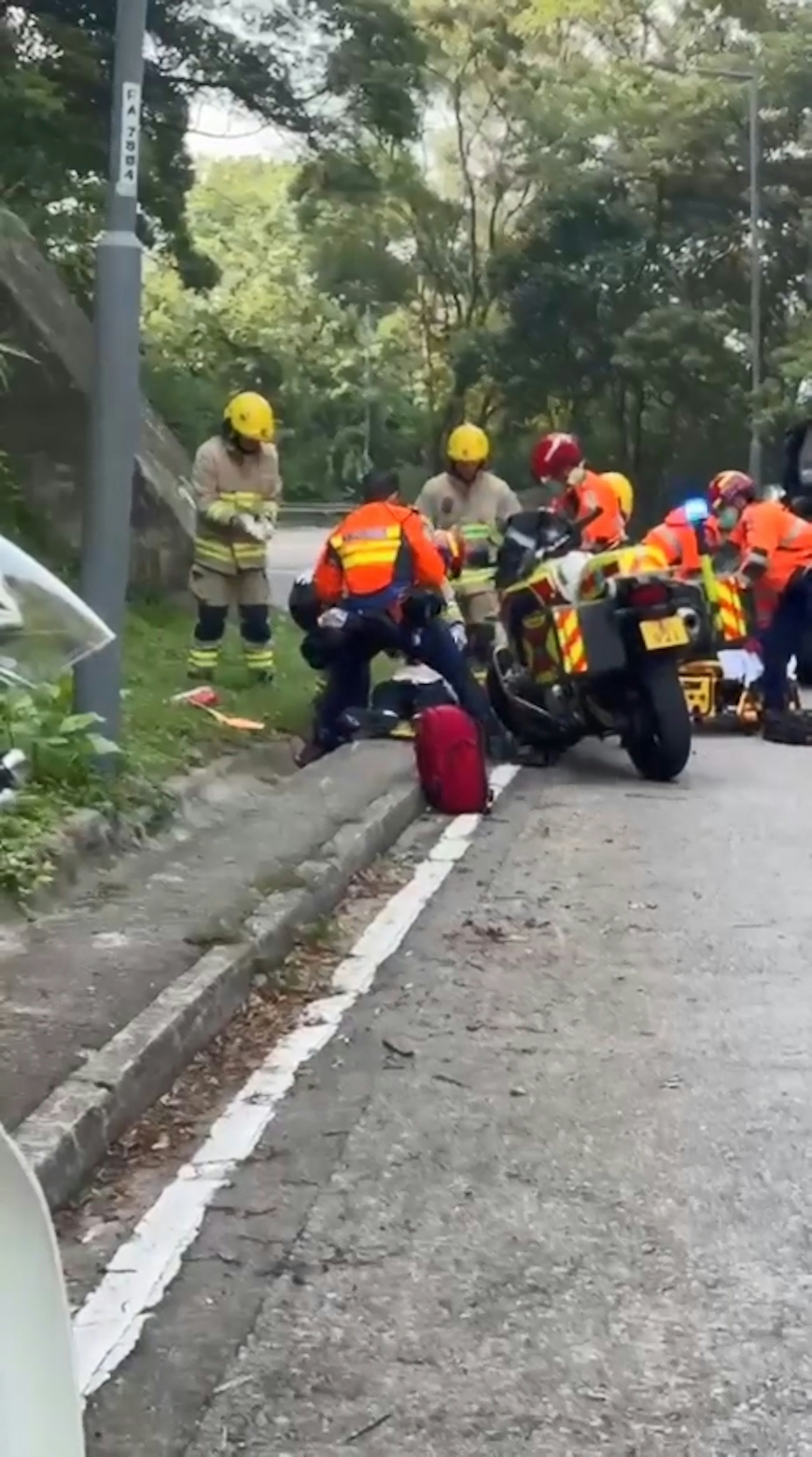 荃錦公路有電單車失事,鐵騎士倒地重創昏迷,救護員即場為他進行心外壓急救,惟集送院搶救後不治。(網上影片截圖)
