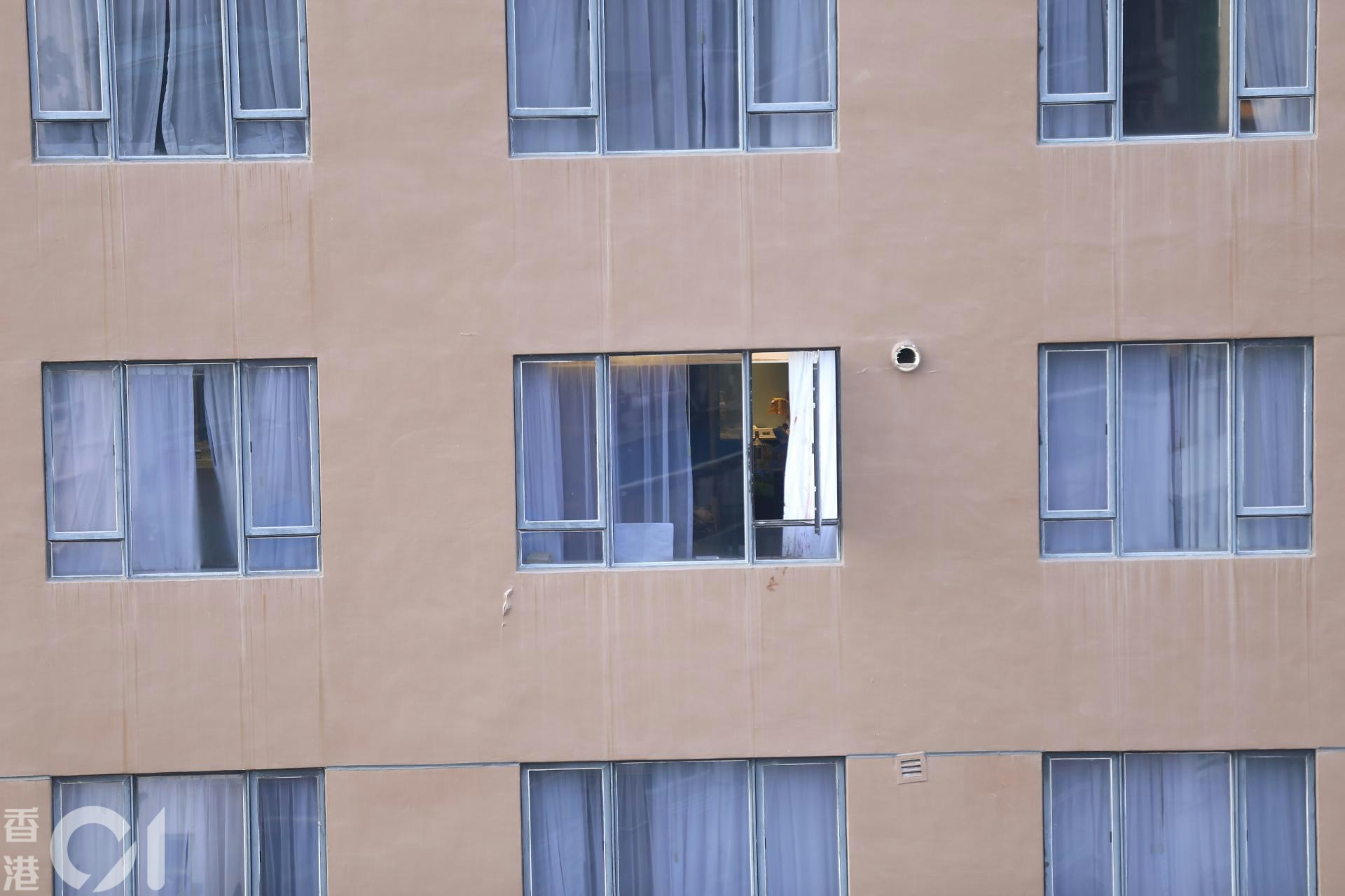 現場所見，酒店中層一個窗戶敞開，白色窗簾及外牆染有血迹。（馬耀文攝）