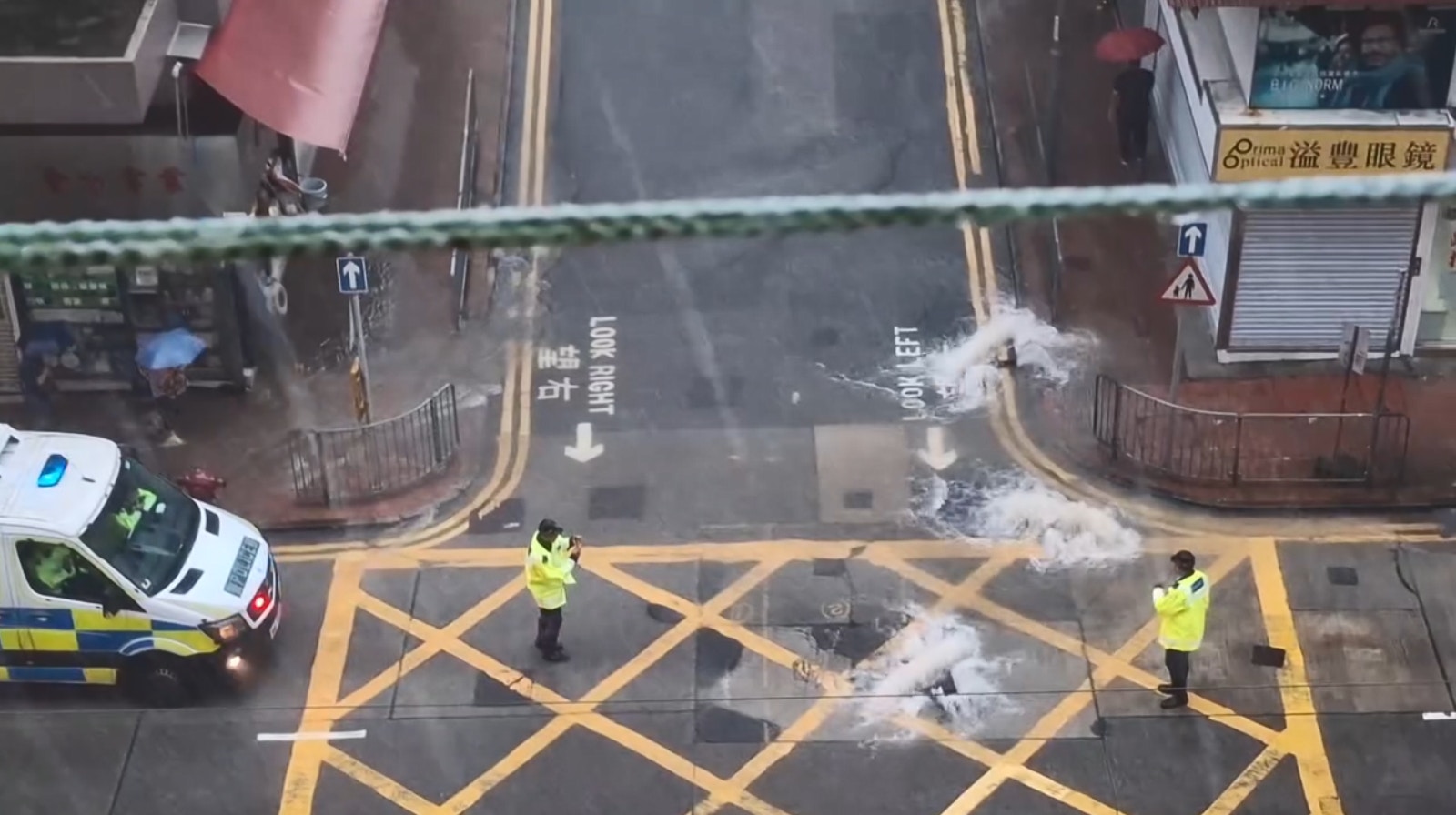 現場兩名警員站在馬路中央指揮交通，警車停泊在路邊戒備。（網民Mui Mui圖片）