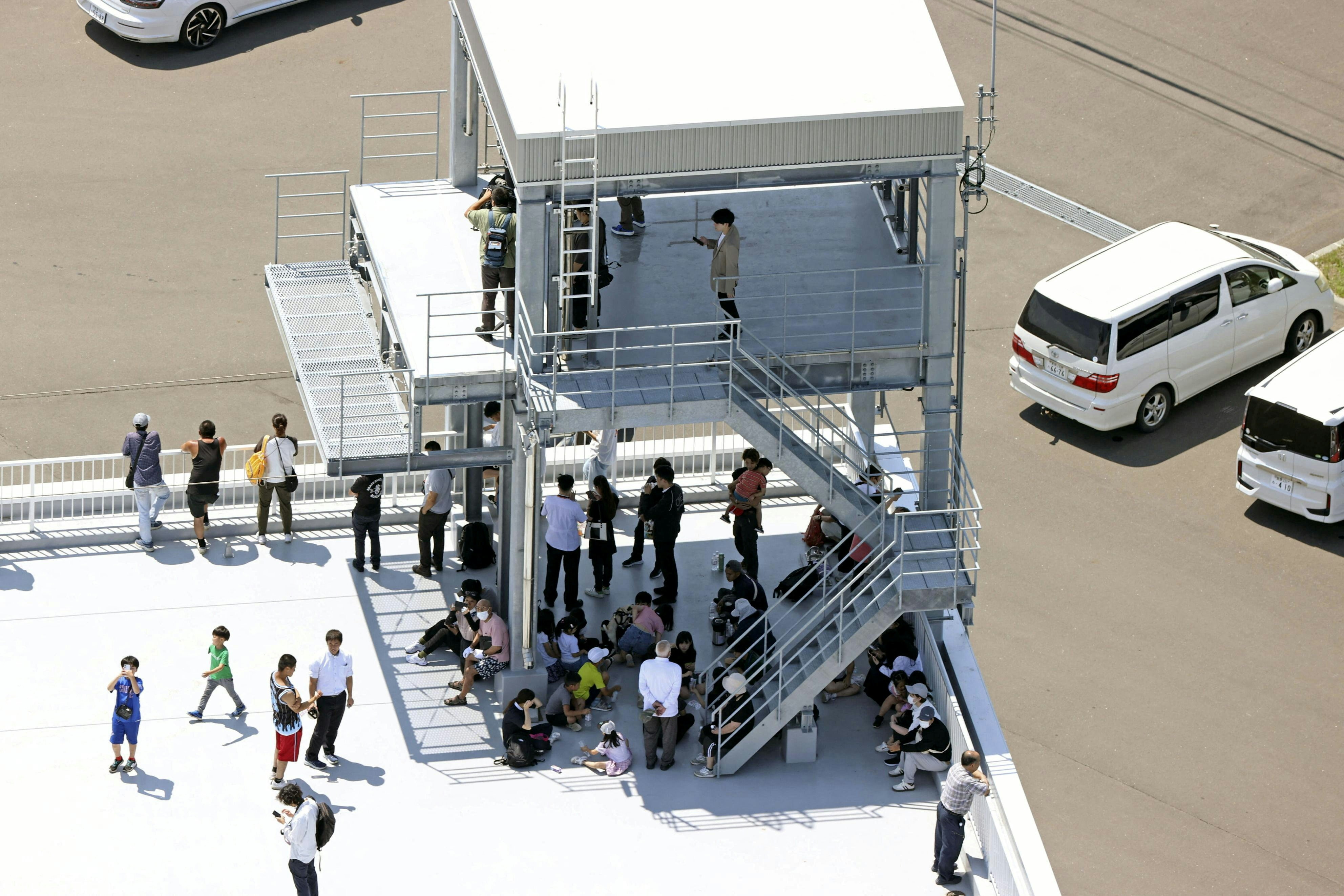 日本海啸：2025年7月30日，俄罗斯堪察加半岛发生强震并引发海啸警报，日本发布疏散警报后，北海道穆川町的巿民到天台暂避。（共同社/Reuters）