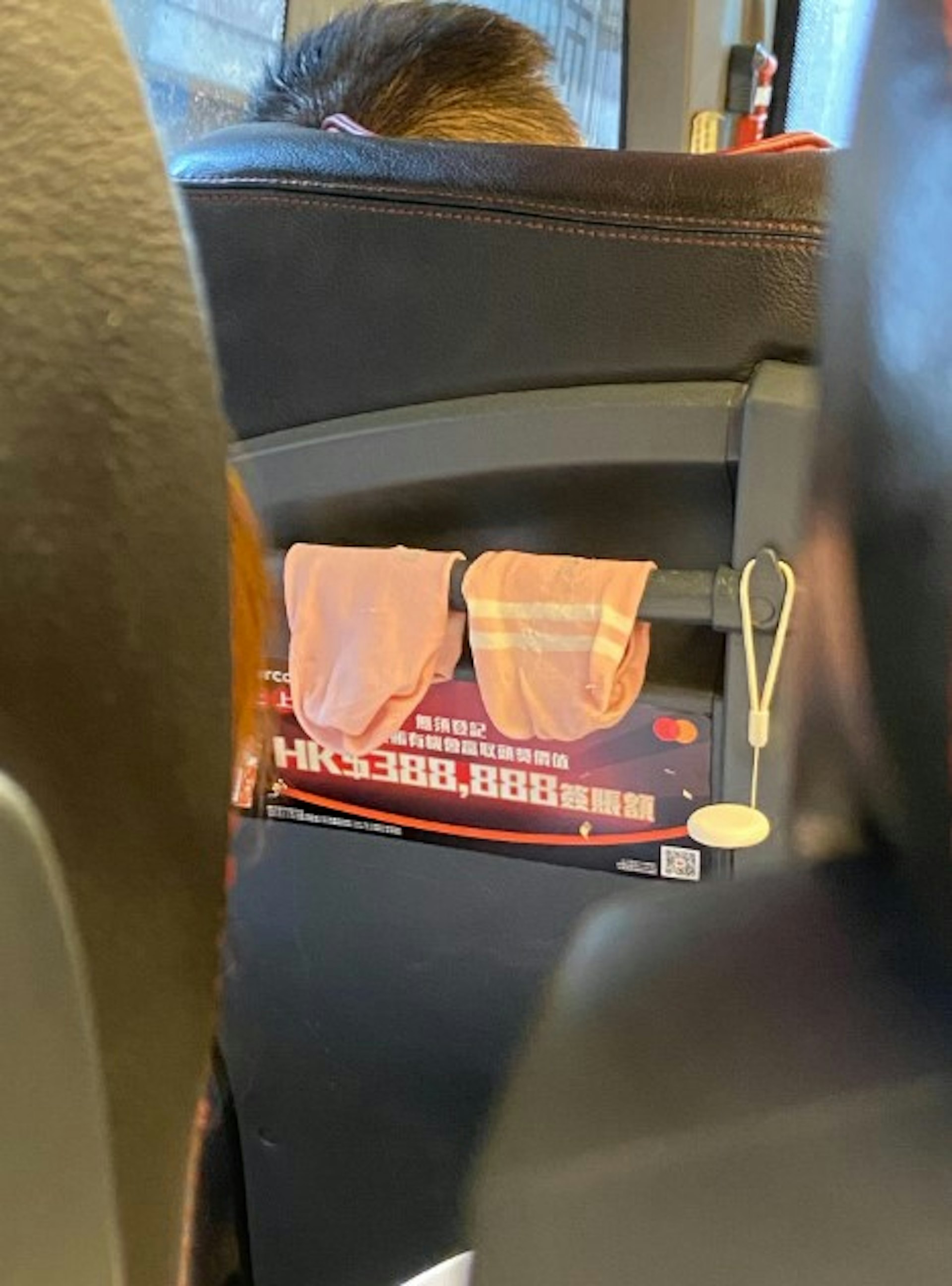 城巴女乘客將一對粉紅色、濕透襪子晾放至扶手柄上。(「threads.@irenelan519_」圖片)