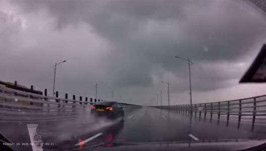 Tesla在左邊駛出，車速甚高濺起地面積水。（車cam截圖）