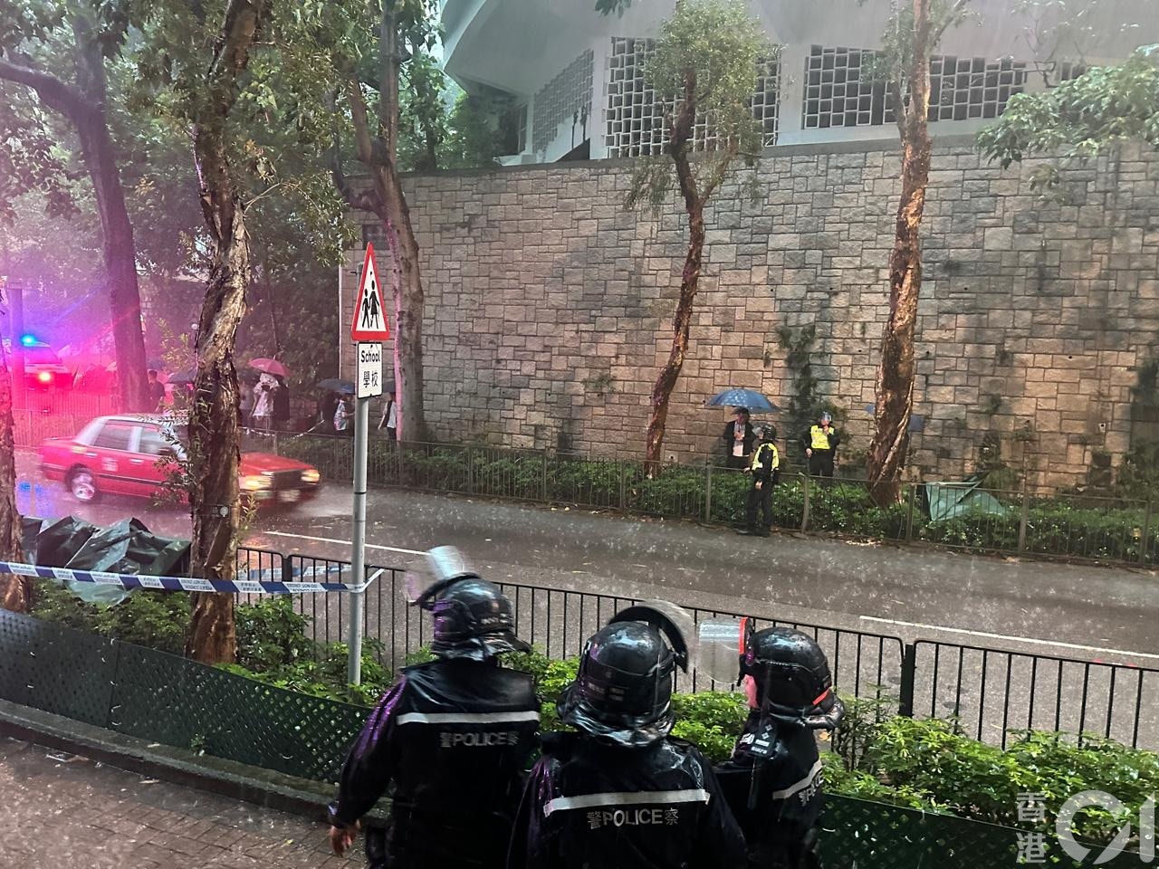 死者腳部跌在嘉諾撒聖方濟各書院外的樹下,身體則跌在對面馬路的另一棵樹下,惟頭顱不知所終;警方用綠色帳篷遮蓋屍體。(羅敏妍攝)