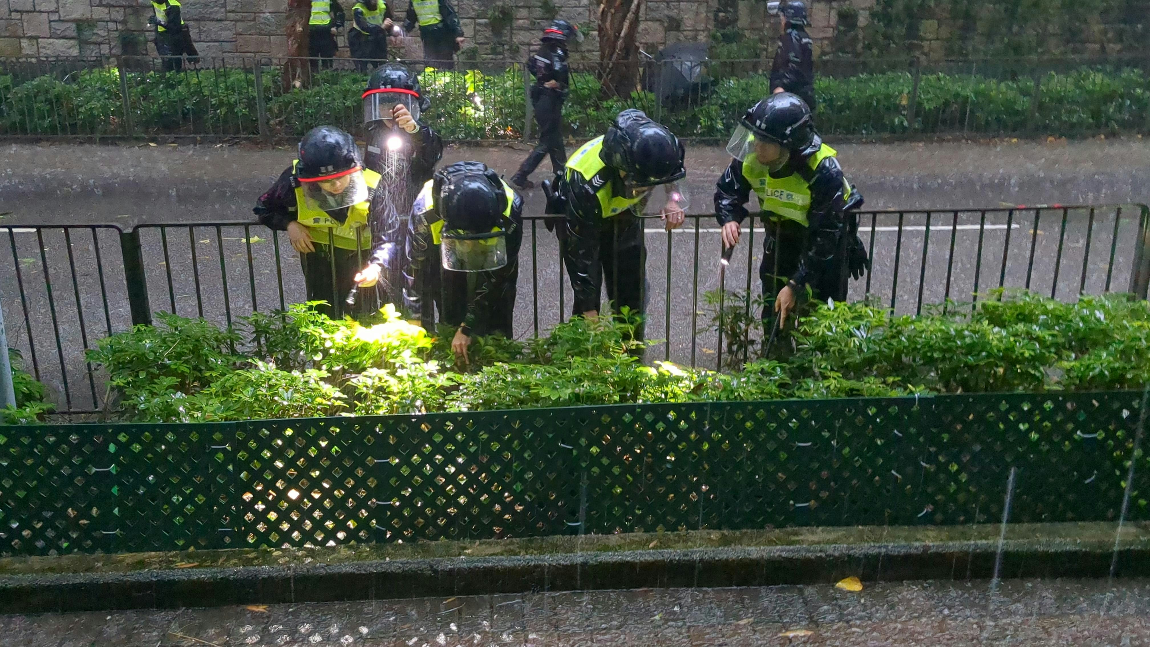 警方冒黑雨找尋死者頭顱。（ 黃偉民攝）