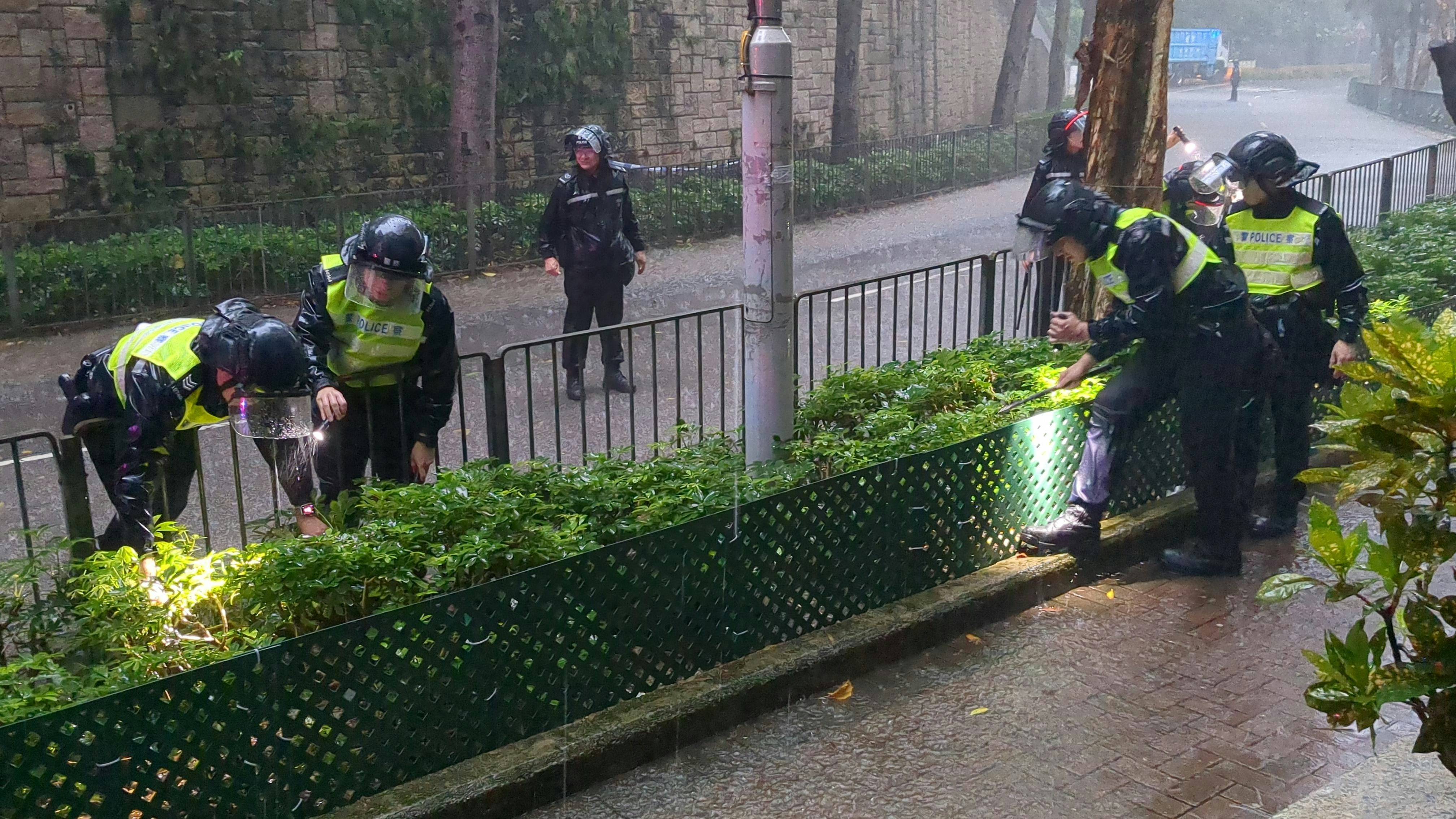 警方冒黑雨找尋死者頭顱。（ 黃偉民攝）