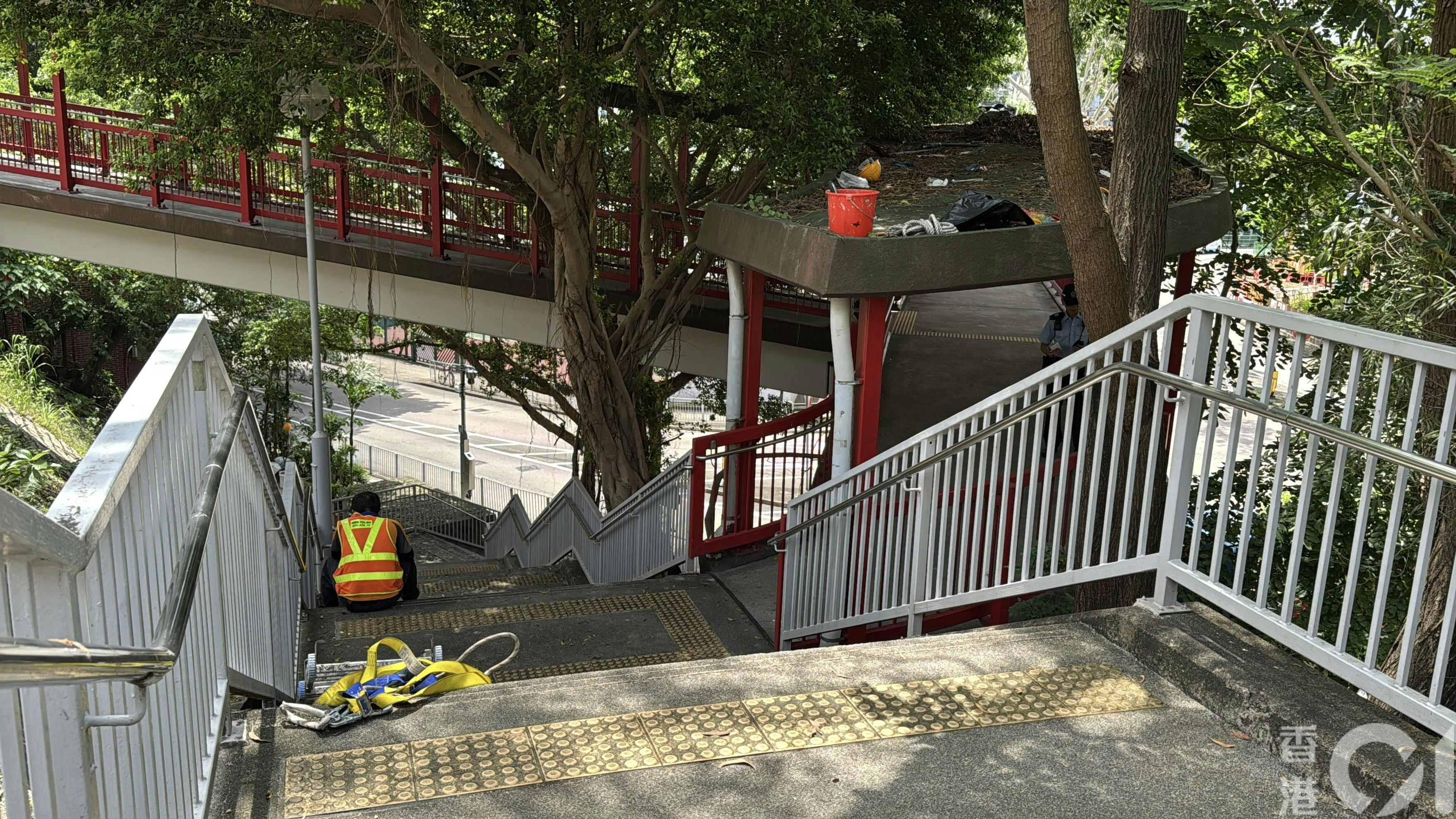 一名男工人在行人天橋上清理樹葉期間突然暈倒。（翁鈺輝攝）