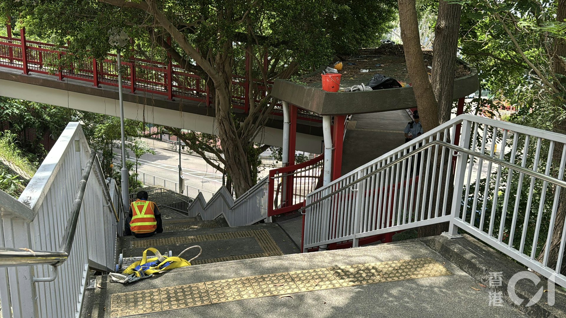 一名男工人在行人天橋上清理樹葉期間突然暈倒。(翁鈺輝攝)