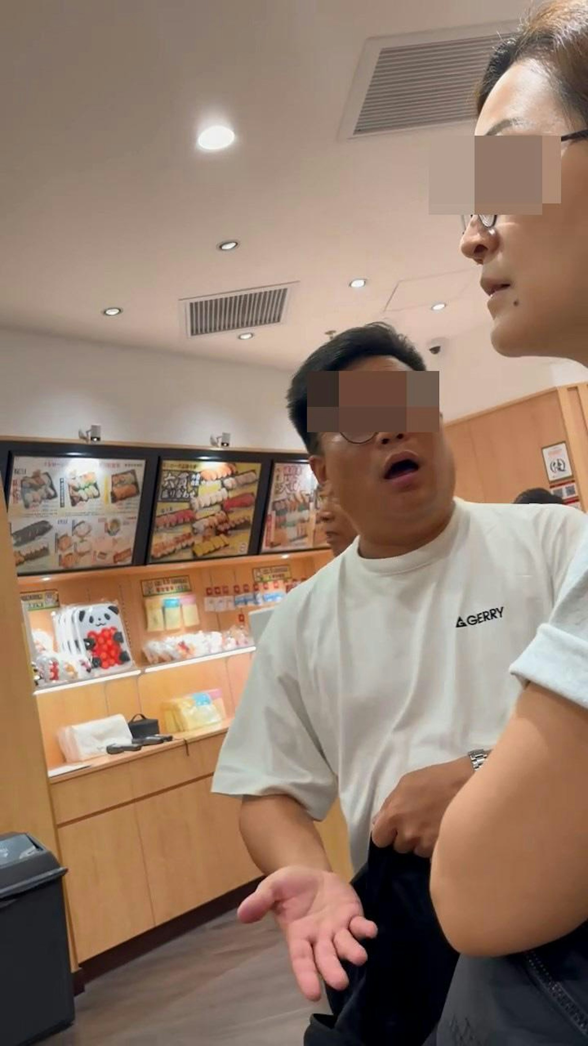 一家三口中的疑似母親,正「叉起」雙手、黑口黑面望着叫號職員方向等候,疑似父親站在旁邊一直手舞足蹈大動作「發牢騷」。(Threads@the.stuns)