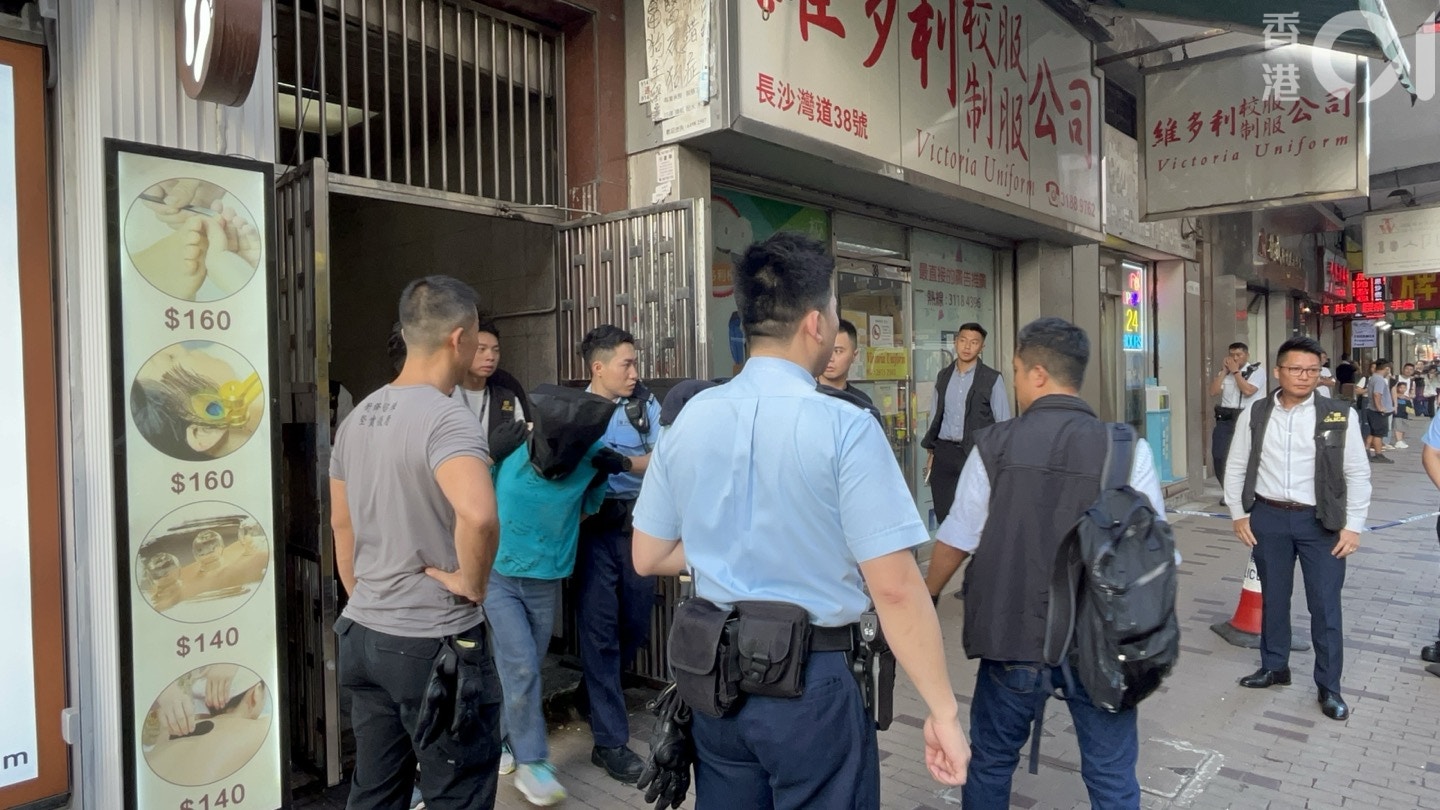 一名涉案女亲友被捕，黑布蒙头带走。（戴慧丰摄）