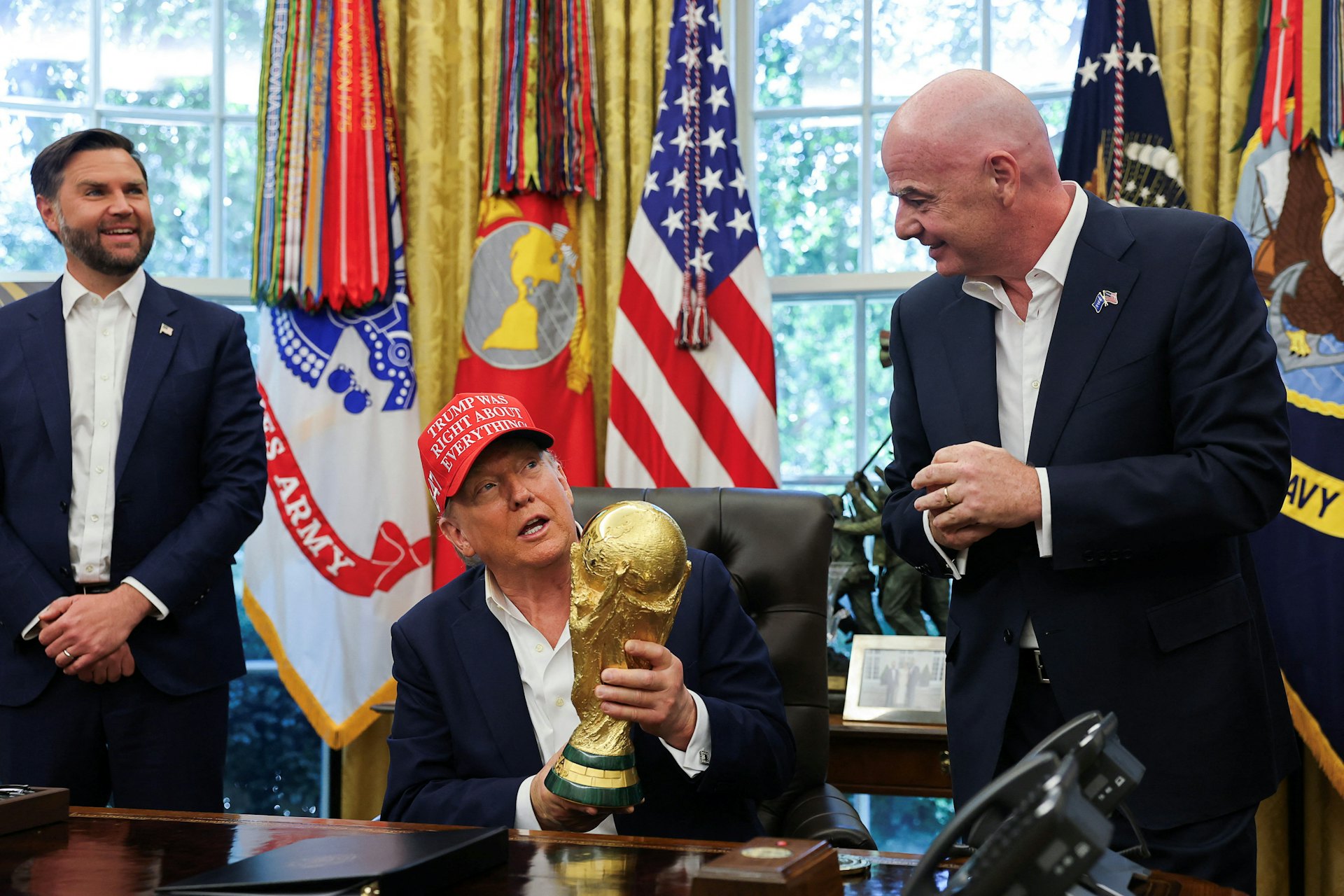 2025年8月22日,美國華盛頓,總統特朗普(Donald Trump,中)在白宮橢圓形辦公室手持國際足協世界盃獎杯,宣布12月將在華盛頓進行2026世界盃抽籤儀式。副總統萬斯(JD Vance,左)和國際足協主席恩芬天奴(Gianni Infantino,右)站在他身旁。(Reuters) 2025年8月22日,美國華盛頓,總統特朗普(Donald Trump,中)在白宮橢圓形辦公室手持國際足協世界盃獎杯,宣布12月將在華盛頓進行2026世界盃抽籤儀式。副總統萬斯(JD Vance,左)和國際足協主席恩芬天奴(Gianni Infantino,右)站在他身旁。(Reuters)