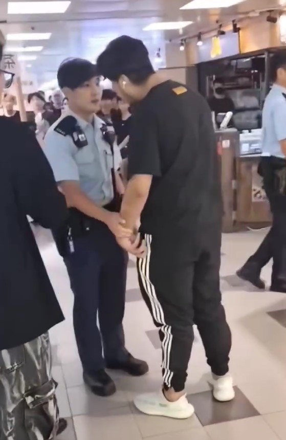 警員用手觸碰該名男子的手，男子情緒激動。(網上片段截圖)