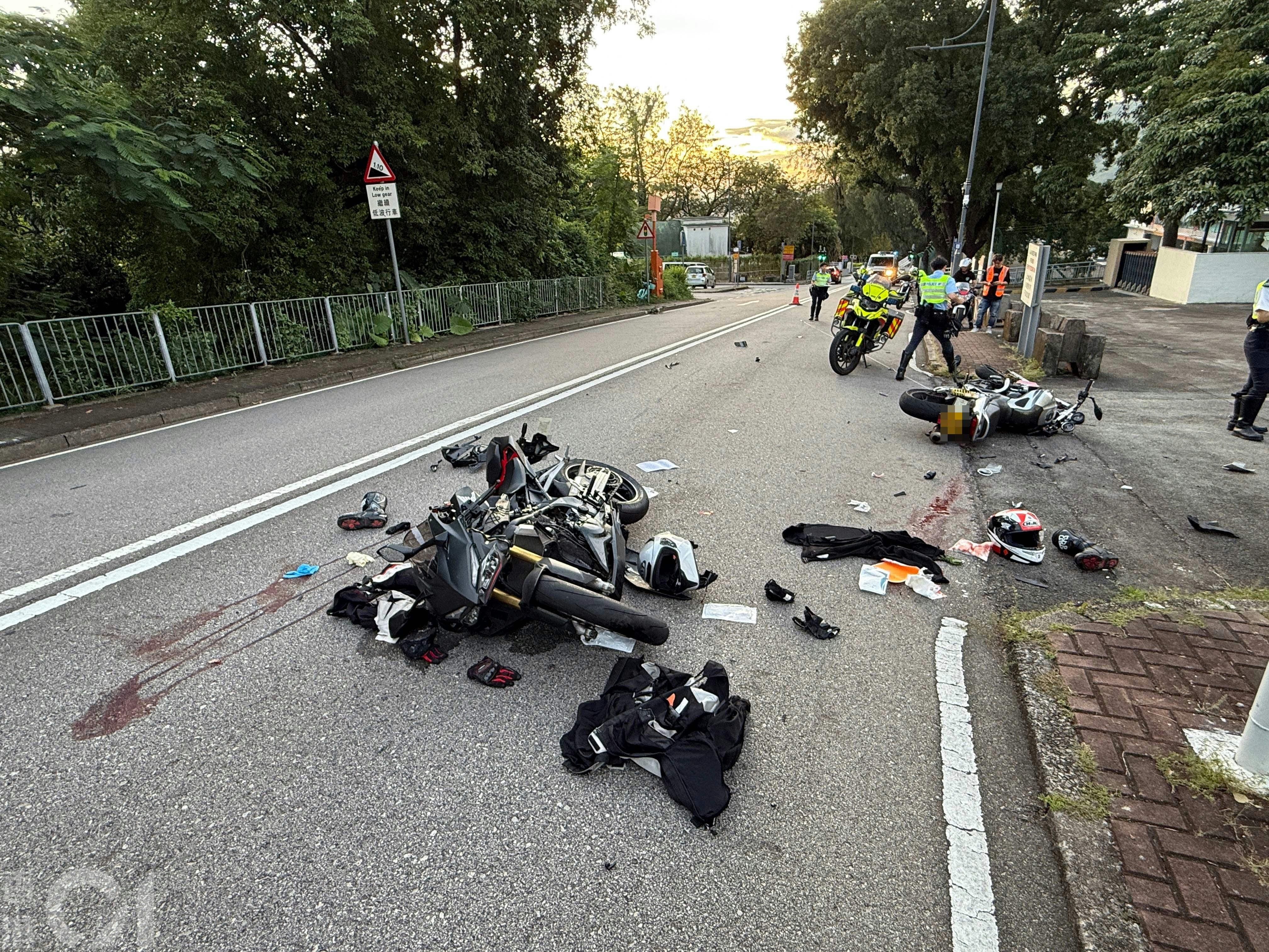 兩輛涉事電單車均嚴重損毀，零件散落一地；地上亦遺留血跡。（羅日昇攝）
