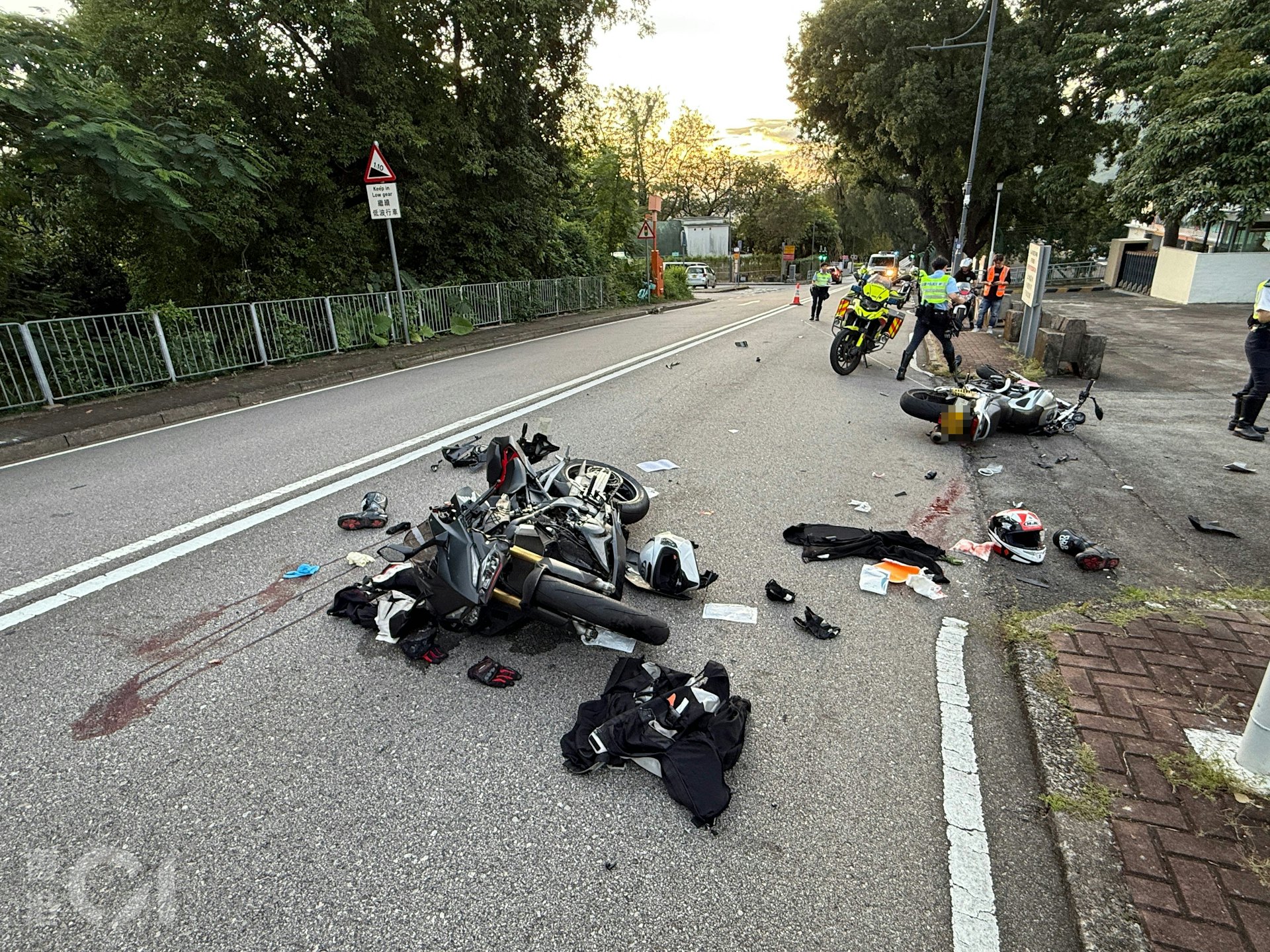 兩輛涉事電單車均嚴重損毀,零件散落一地;地上亦遺留血跡。(羅日昇攝)