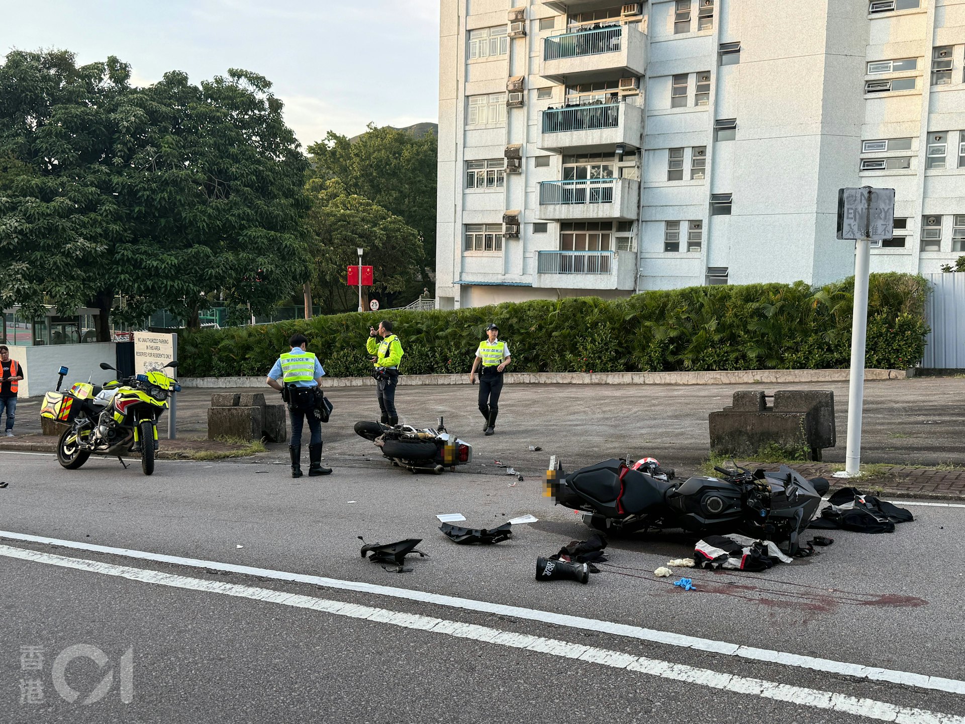 兩輛涉事電單車均嚴重損毀,零件散落一地;地上亦遺留血跡,警方到場調查。(羅日昇攝)