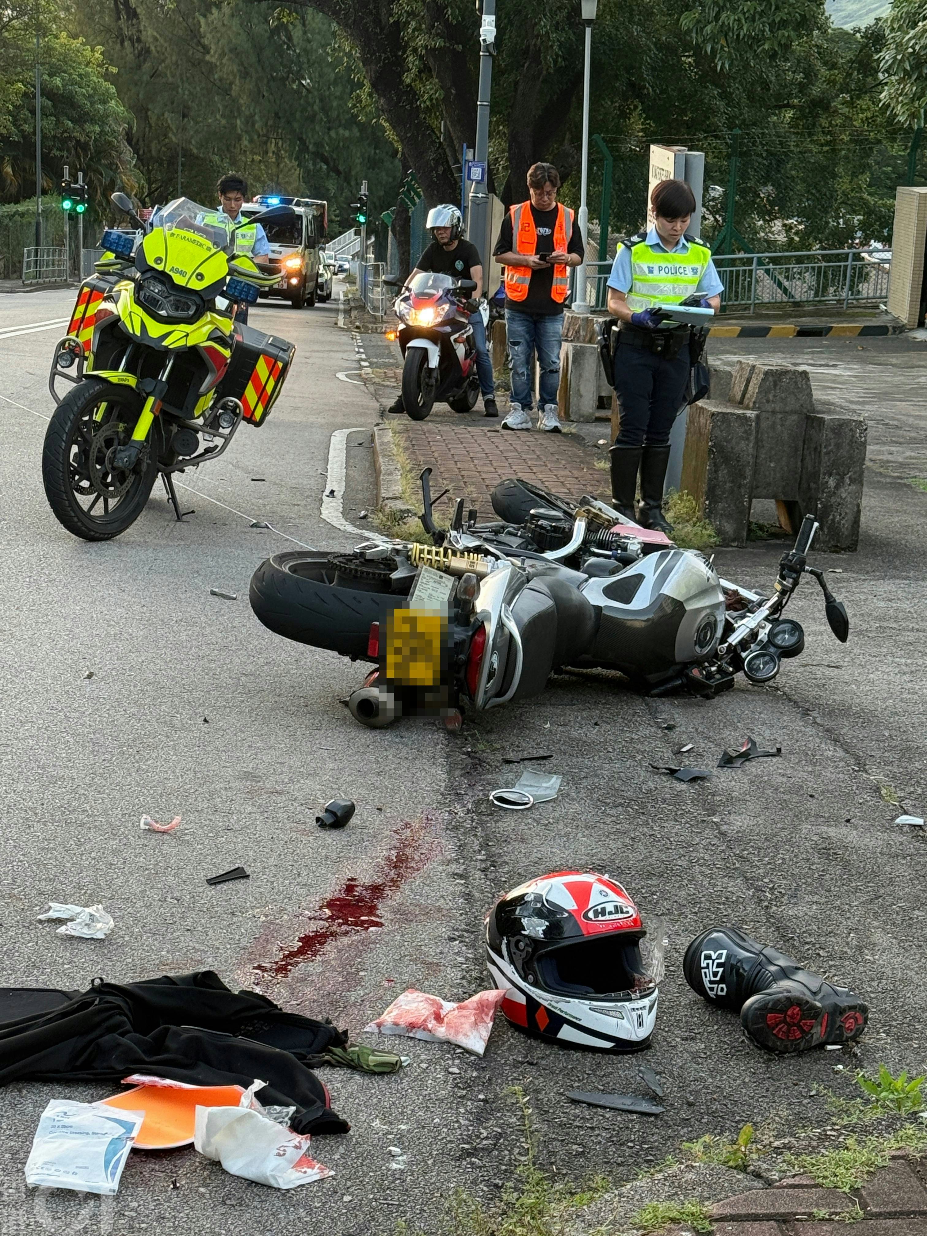 兩輛涉事電單車均嚴重損毀，零件散落一地；地上亦遺留血跡。（羅日昇攝）