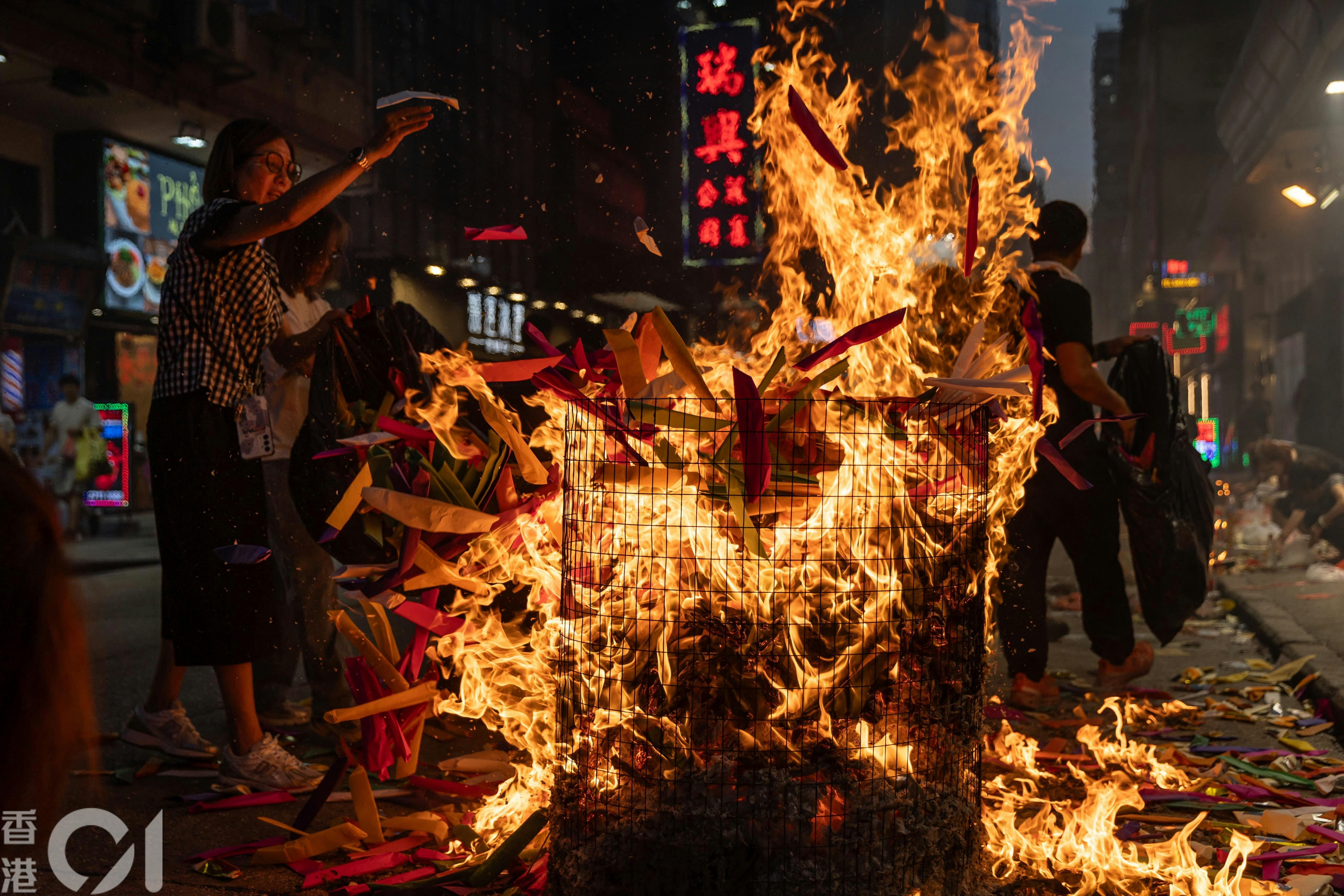 农历七月路边火光摇曳，市民焚衣祭祀，布施孤魂，祈求平安，既是古老传统，亦是街头巷尾的社区风景。（廖雁雄摄）