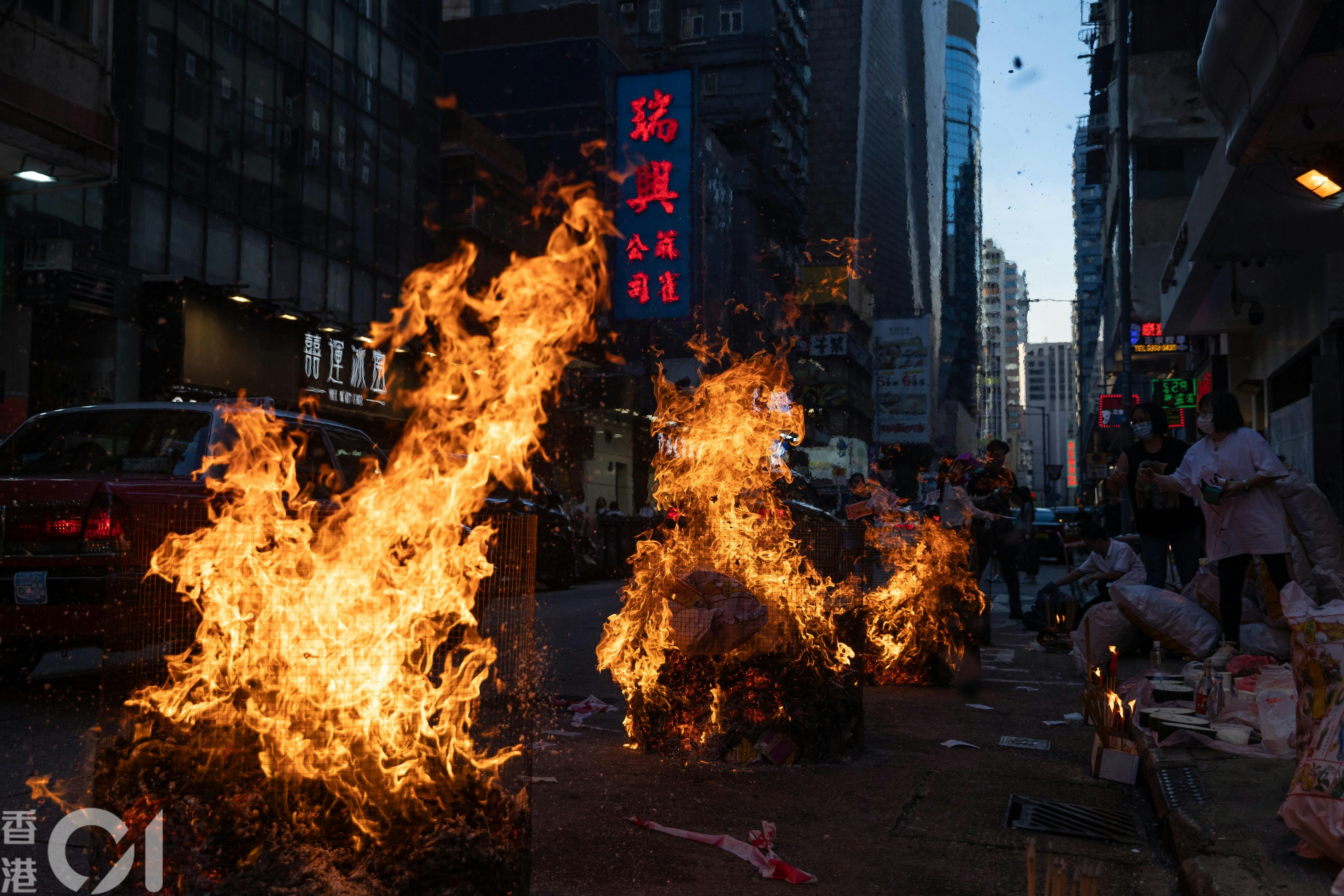 农历七月路边火光摇曳，市民焚衣祭祀，布施孤魂，祈求平安，既是古老传统，亦是街头巷尾的社区风景。（廖雁雄摄）