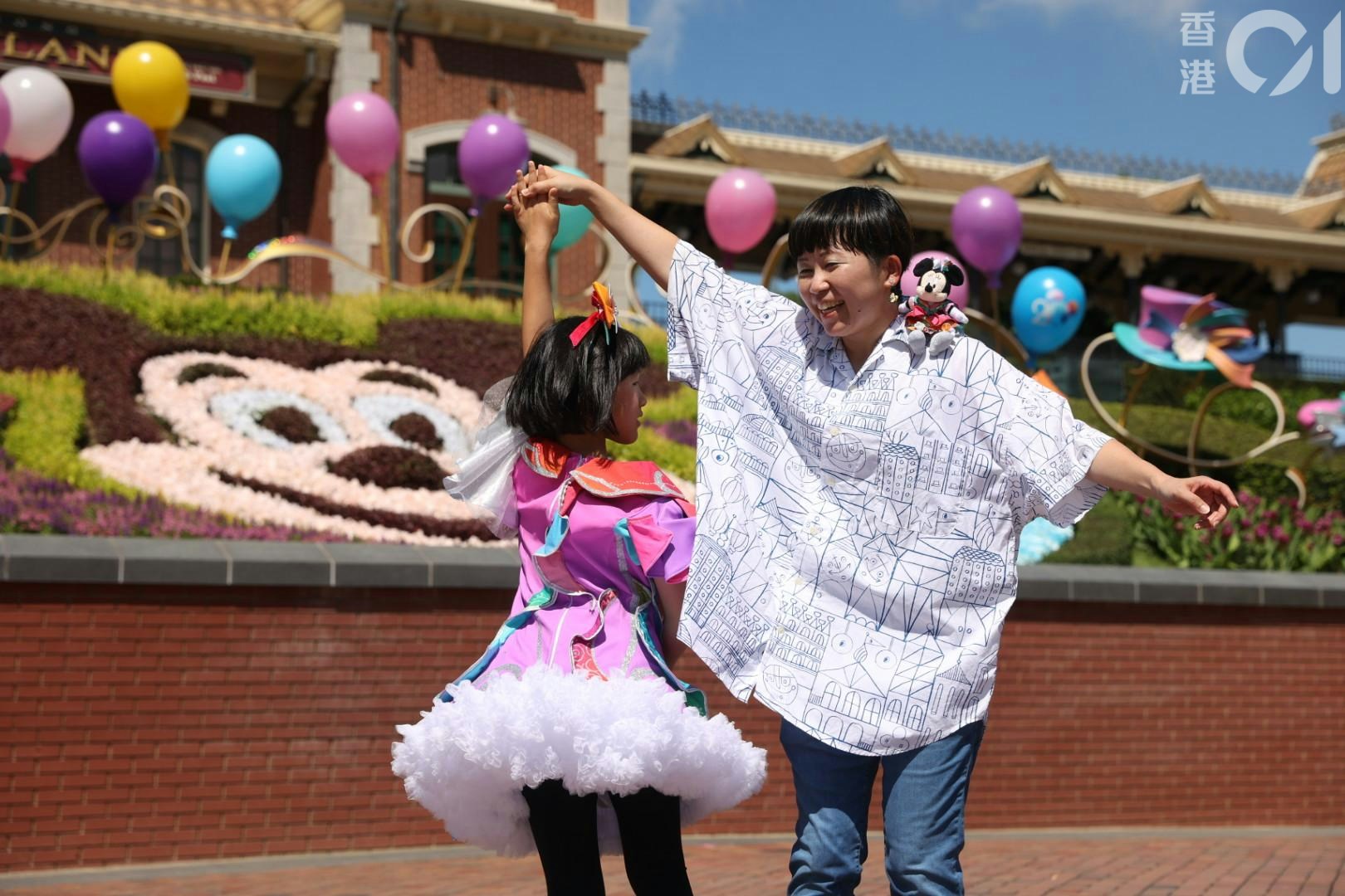 Sayaka Kishi稱，多年來曾到訪香港迪士尼樂園9次，為慶祝迪士尼20周年，她用上三天時間，親手為女兒設計今天穿的衣服，笑言這套衣服閃亮多彩（shiny and colourful）。（陳葦慈攝）