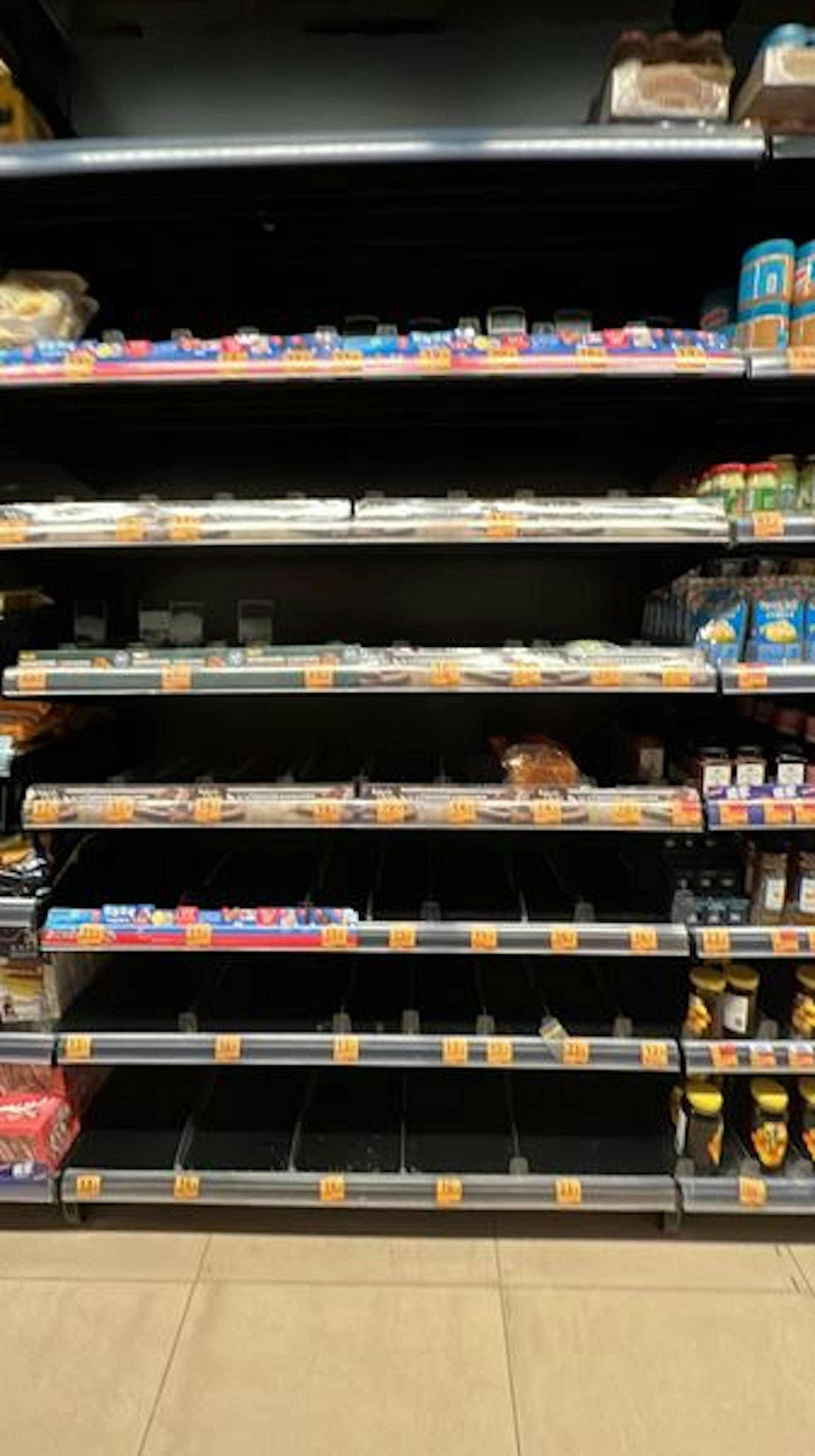 惠康、百佳、Aeon等不少超市、商戶貨架的菜、麵包、杯麵等食物被搶購一空。(Threads@____rh)